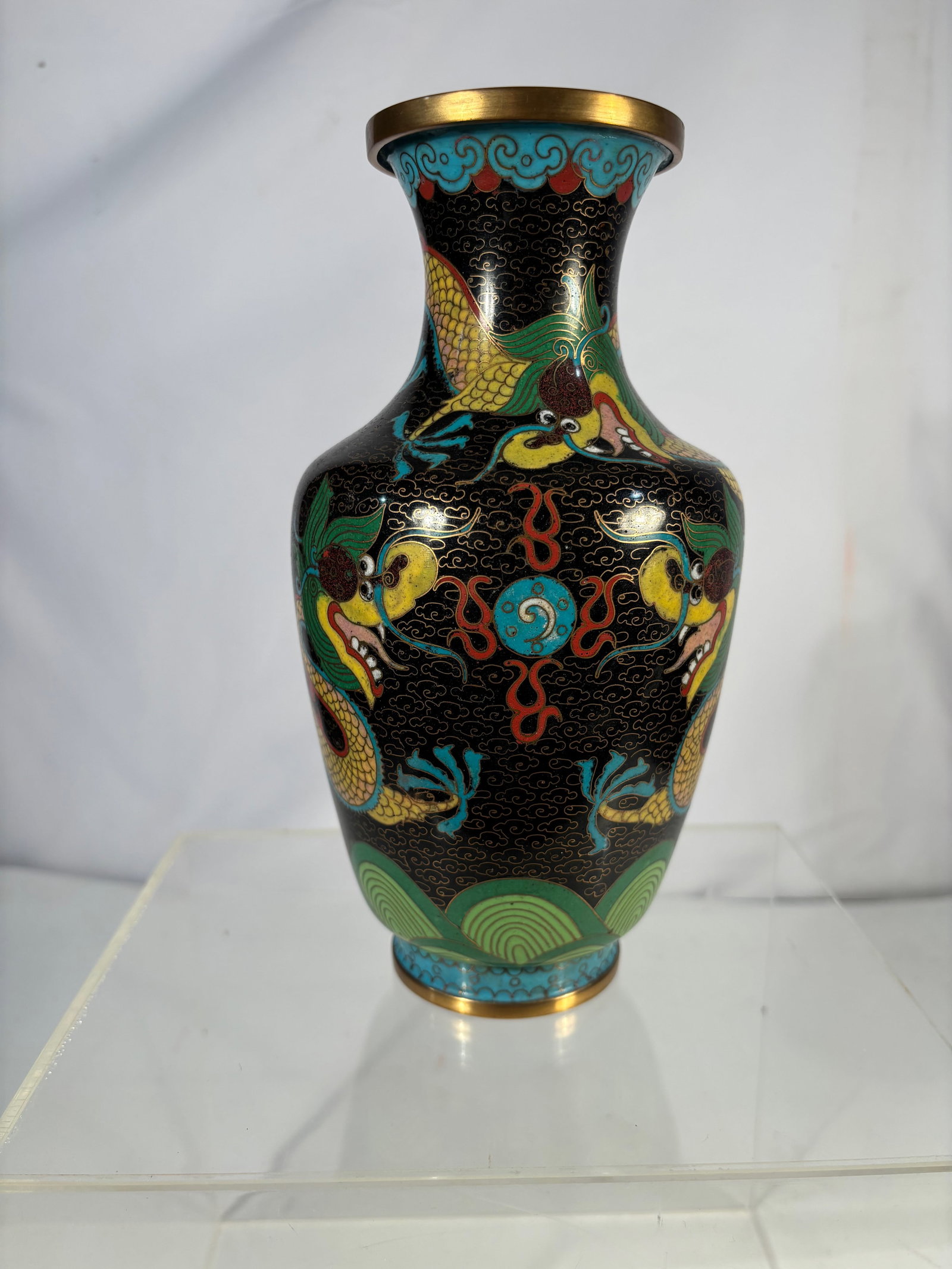 A Chinese Cloisonné Enamel Vase with Dragon Motif: A Chinese cloisonné enamel vase of baluster form, decorated with two five-clawed dragons amidst scrolling c louds against a black ground. The neck and foot with stylized cloud motifs in turquoise ena