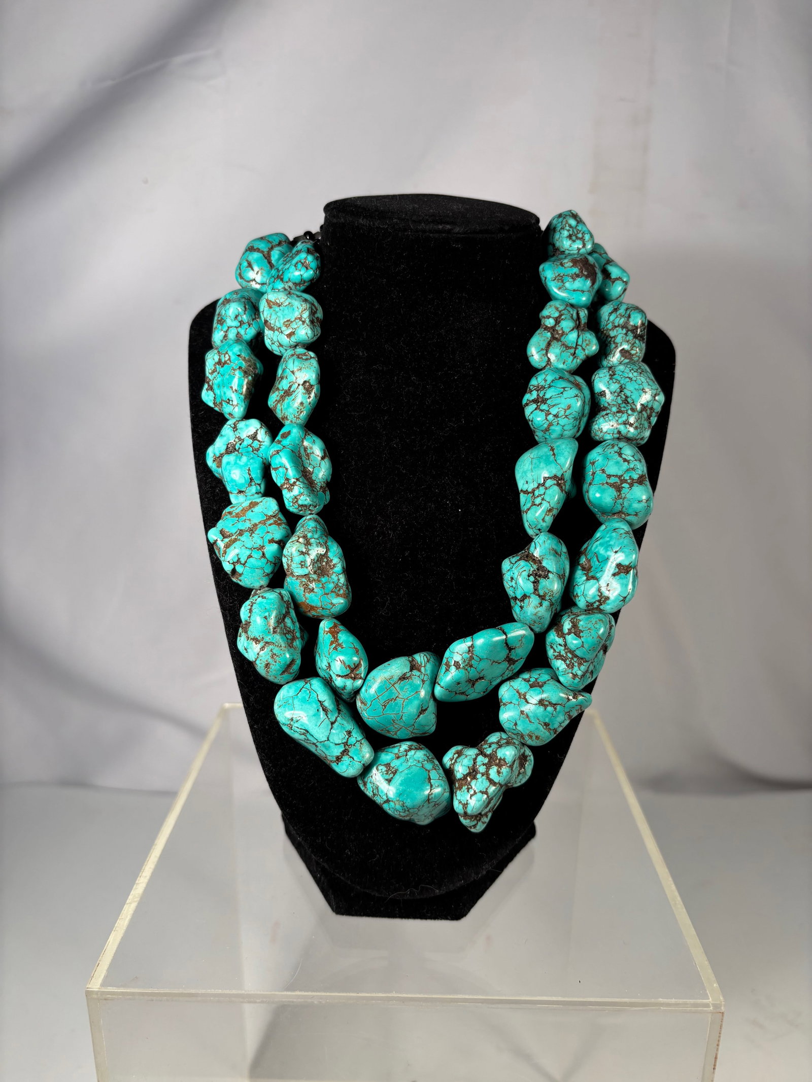 A Large Turquoise Nugget Bead Necklace, 350 grams: Large double-strand necklace composed of irregular turquoise nugget beads with natural dark matrix. The stones display a vibrant blue-green color and organic form. Finished with a clasp and extender c
