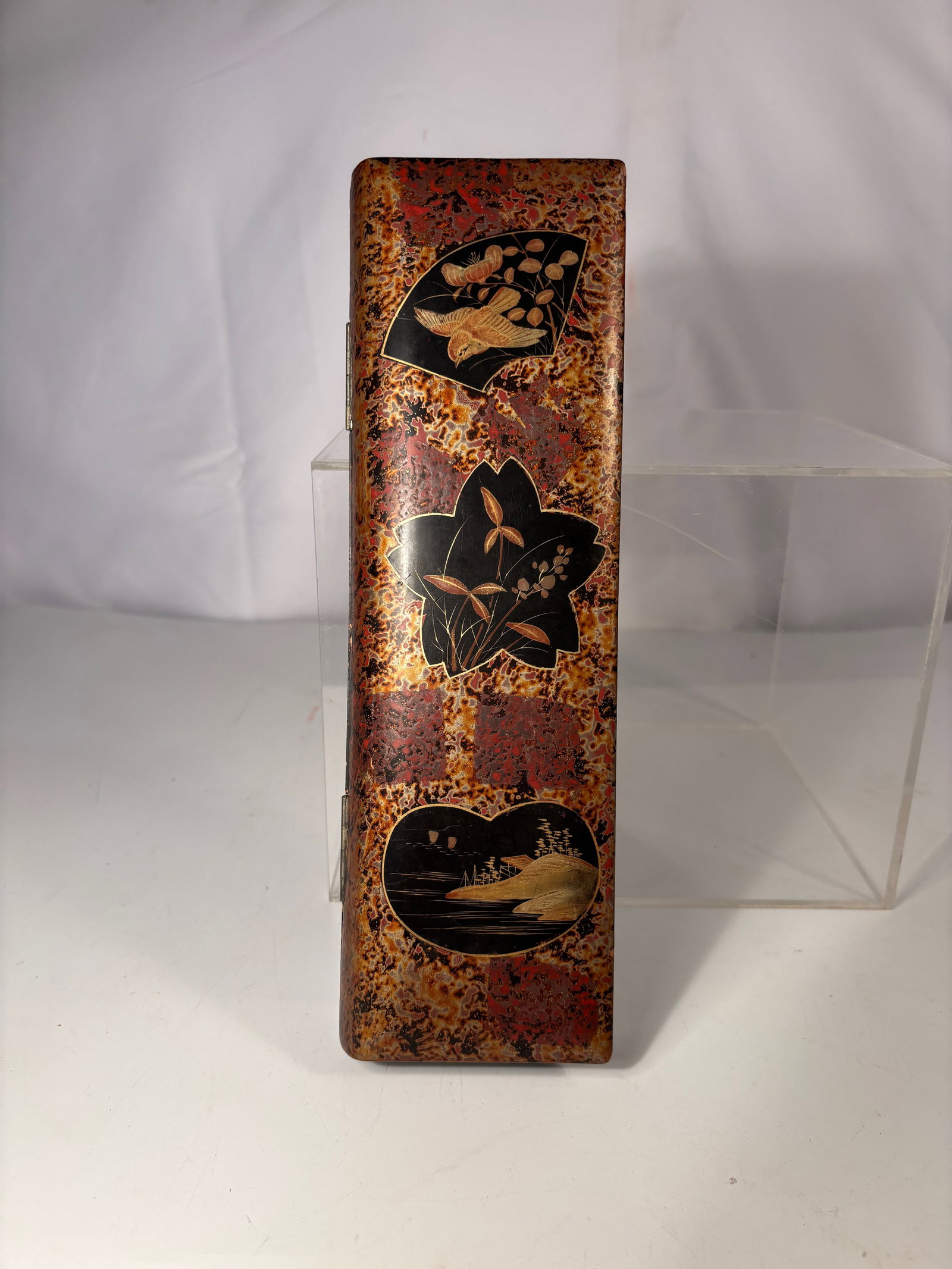 A Japanese Lacquer Inro-Form Box with Gold Makie Decoration: A Japanese lacquer box of elongated rectangular form, decorated in gold maki-e on a mottled brown ground. The exterior features reserves with traditional motifs including a bird, floral elements, and 