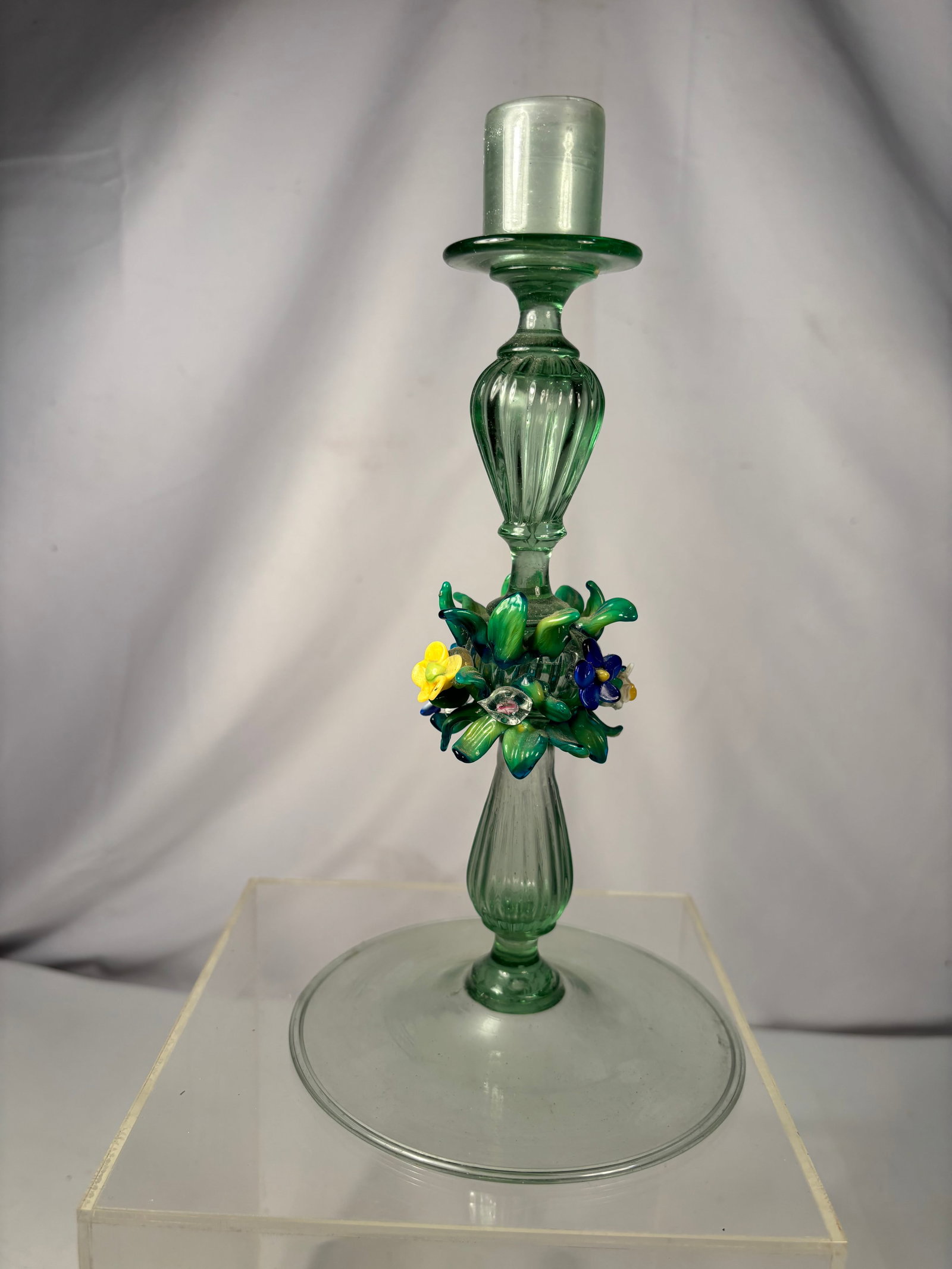 Murano Style Hand Blown Art Glass Floral Candlestick: Hand blown art glass candlestick featuring an elegant light green body with applied multicolor floral and leafy decoration. The stem is embellished with hand-worked flowers in blue, yellow, white, and