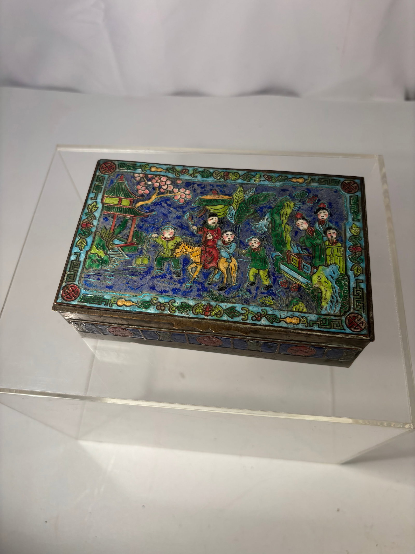 A Chinese Cloisonné Enamel Rectangular Trinket Box with Figural Garden Scene: A fine Chinese cloisonné enamel rectangular box, likely dating to the Republic period or early mid-20th century. The hinged lid is decorated with a colorful figural garden scene featuring attendants,