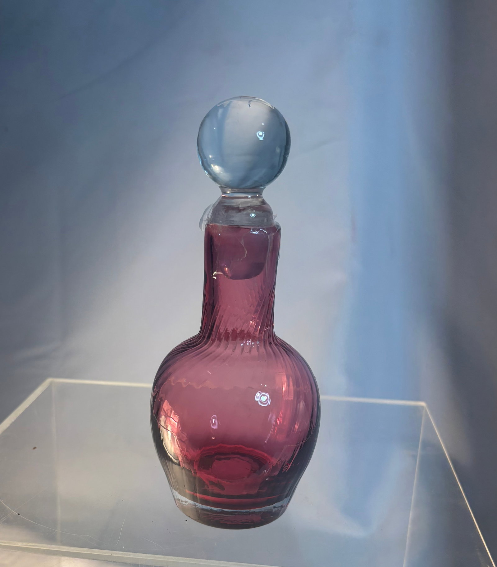 Antique Bohemian Cranberry Glass Perfume Bottle with Opaline Stopper: Antique Bohemian cranberry art glass perfume bottle featuring a rich ruby-pink body with elegant bulbous form and optic-ribbed neck. Retains a matching stopper with opaque opaline-style finial. Hand-b
