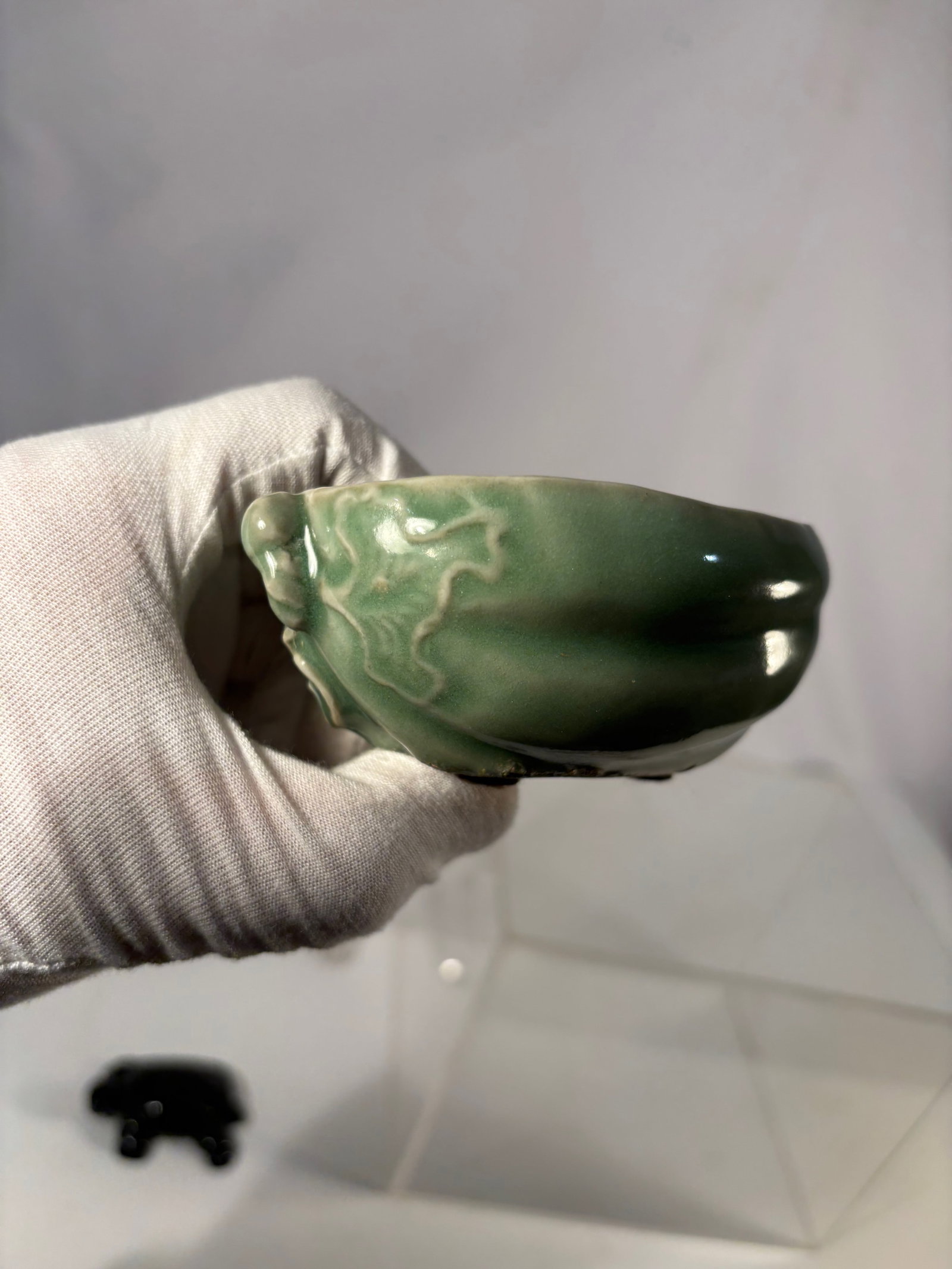A Chinese Green-Glazed Melon-Form Porcelain water pot: Qing dynasty(1644-1912) ;A Chinese green-glazed porcelain water pot modeled in a stylized melon form, the exterior decorated with raised leaf-like relief lines and covered in a glossy celadon-green