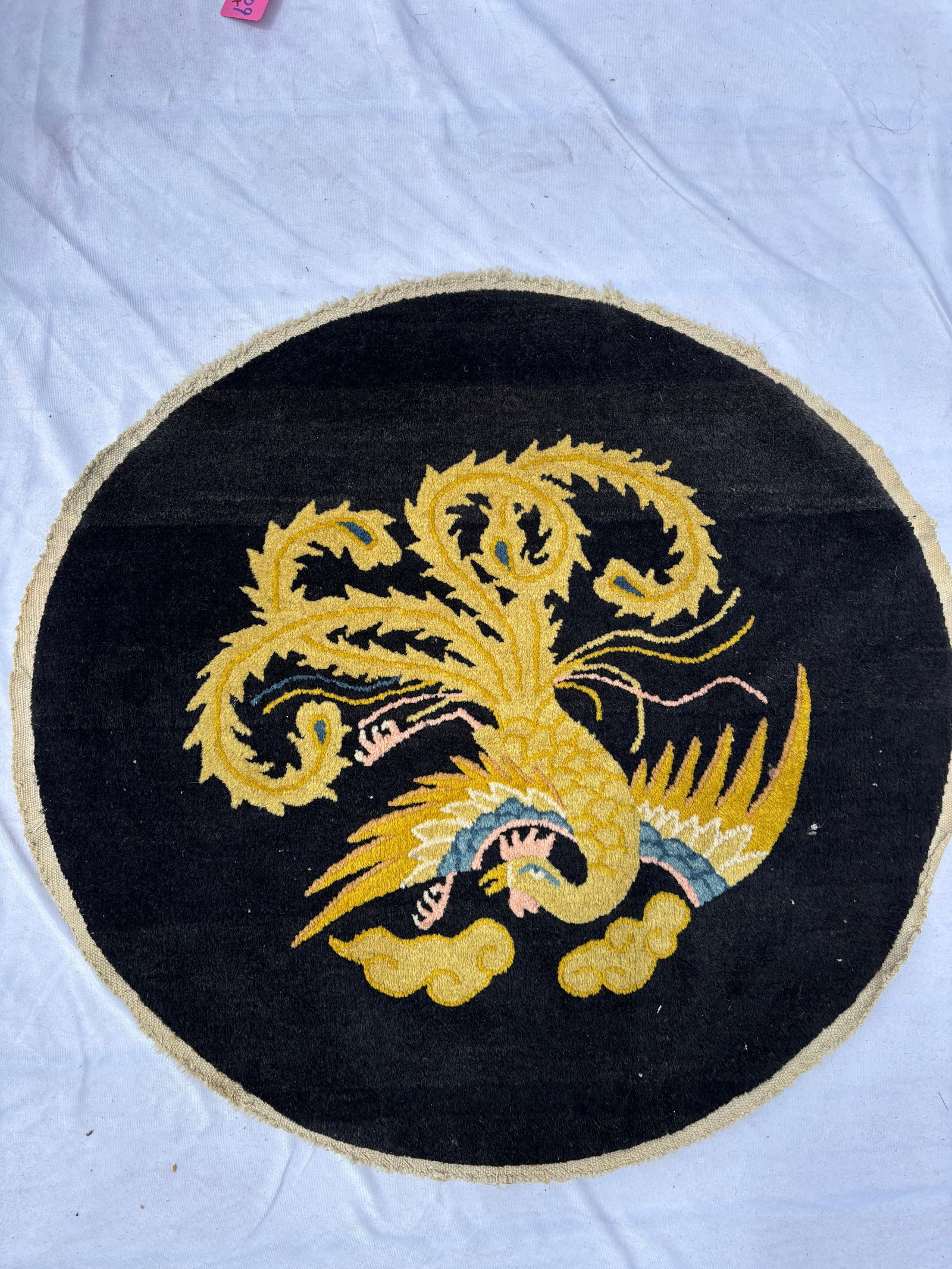 Antique Chinese Peking Rug with Golden Phoenix Design, 26 Inch Diameter: Hand-knotted Chinese Peking rug featuring a stylized golden phoenix on a deep navy to black field. Executed in traditional Chinese decorative style with vibrant yellow, blue, and ivory accents. Measur