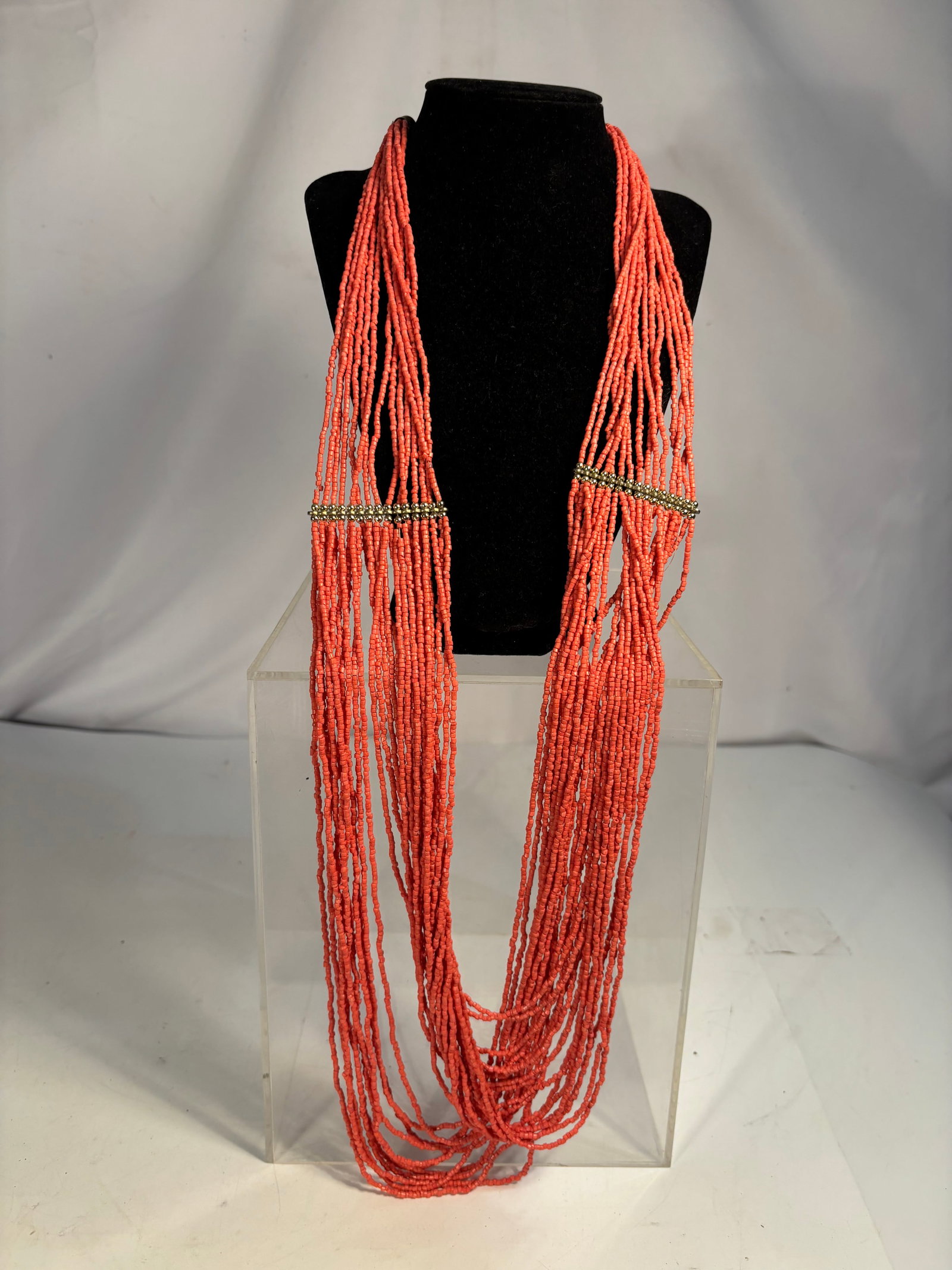 15-Strand Coral-Like Seed Bead Torsade Necklace, 38 Inches: Elegant multi-strand necklace featuring 15 strands of coral-like red seed beads in a layered torsade design. Accented with brass-tone spacer bars and finished with an adjustable chain clasp. Measures 