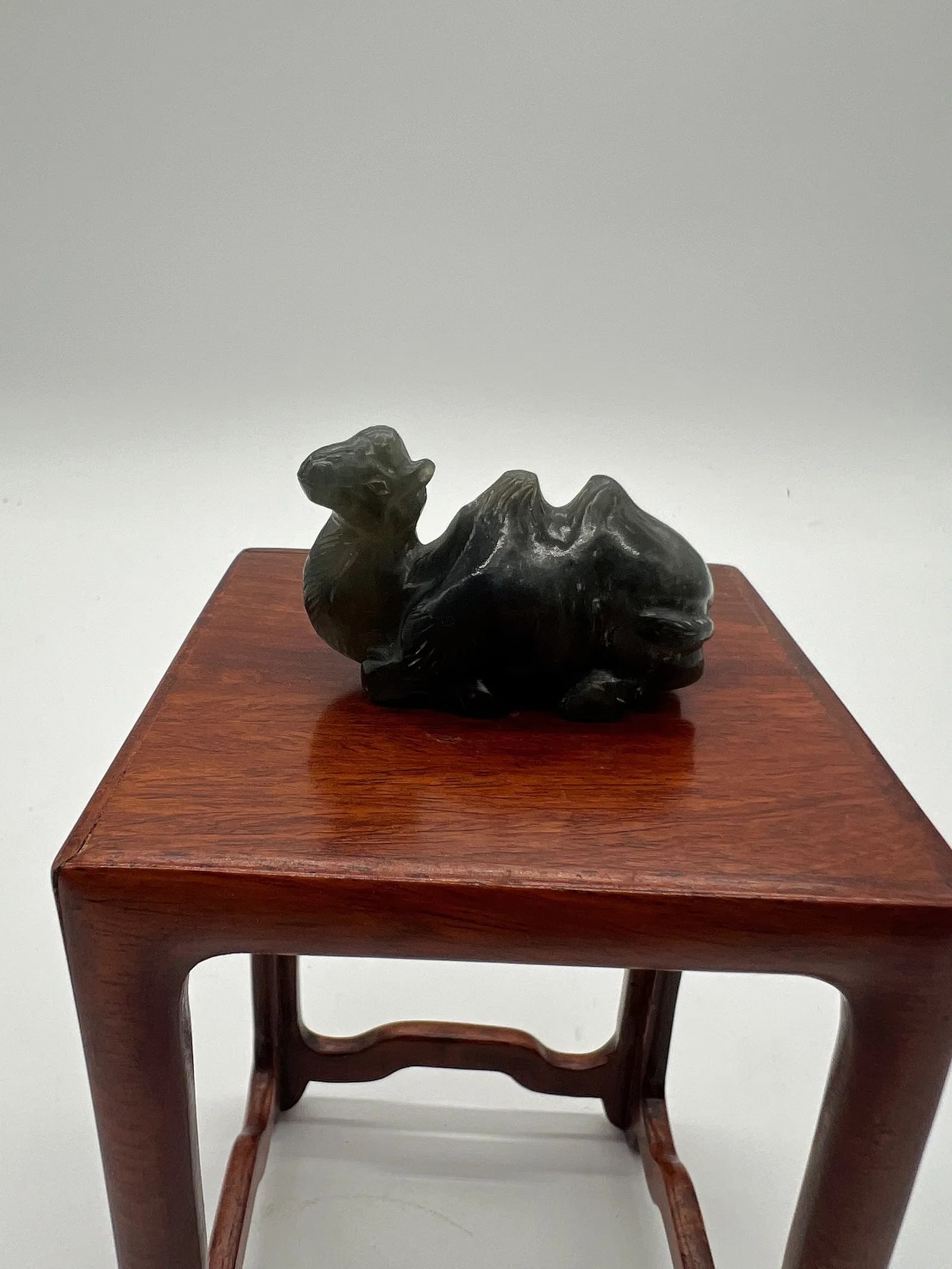 A Chinese hand carved dark green jade camel statue .: Qing Dynasty (1644-1912); The jade features a camel or another creature in a reclining or resting position.Dimensions? Length: 5 cm ; Height : 3 cm