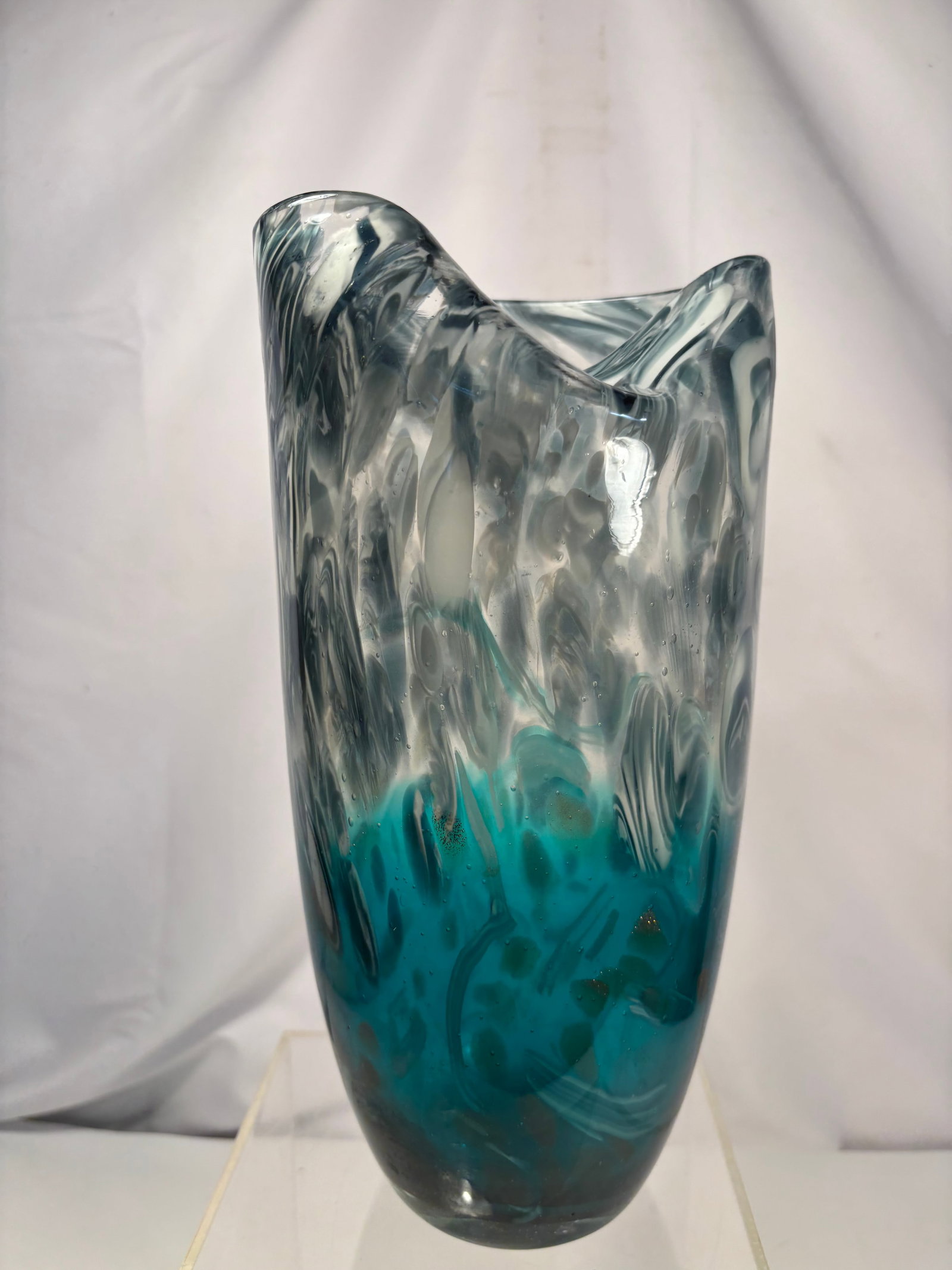 Murano-Style Hand Blown Art Glass Vase in Blue and Clear Swirl Pattern: Hand-blown art glass vase featuring a graceful freeform flared rim with a striking blue and clear swirling pattern. The thick cased glass showcases controlled internal movement and an organic sculptur