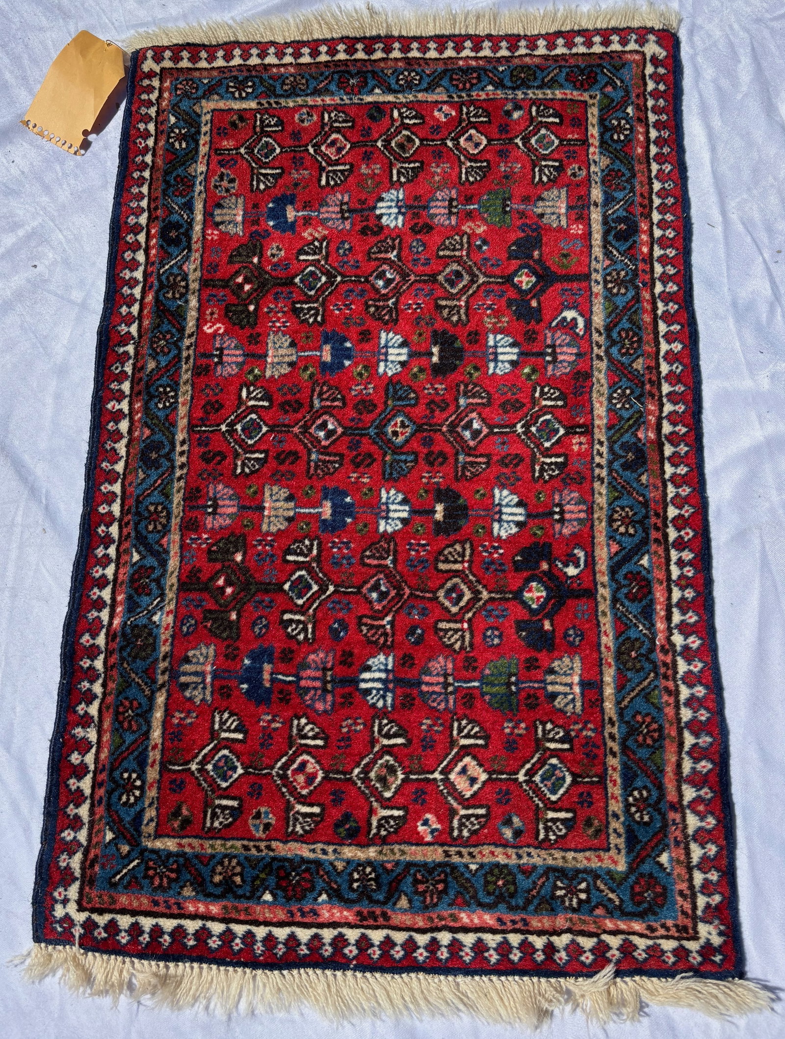 Vintage Persian Hamadan Hand-Knotted Wool Rug 34 x 21 in.: Hand-knotted Persian village rug with repeating geometric motifs on a red field within dark blue borders. Wool pile with fringe ends. Mid-20th century. Approximate size: 34 x 21 in. Inventory # 070999
