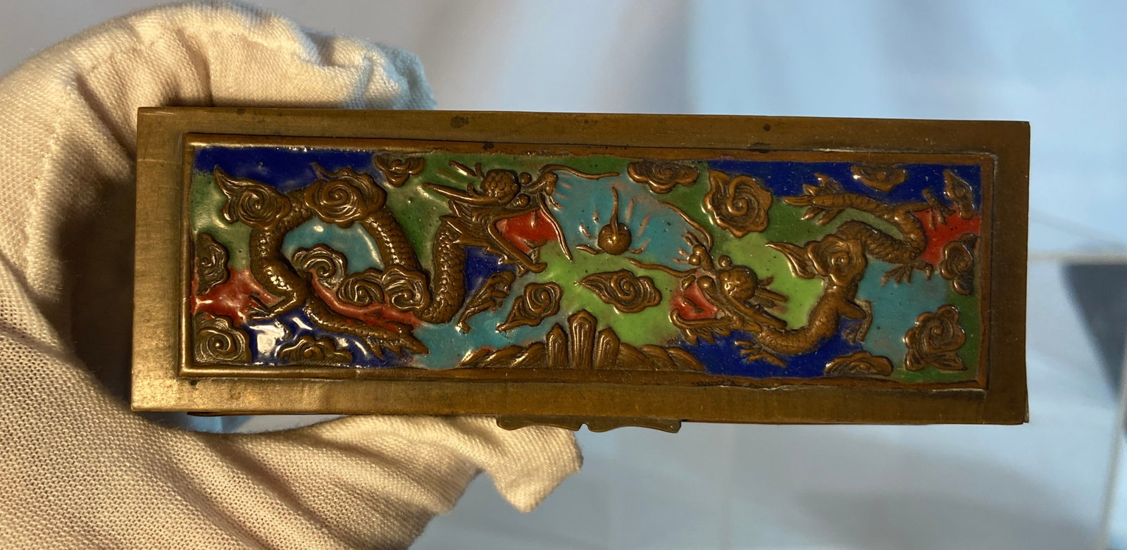 Chinese Cloisonné Brass Stamp Box, Marked CHINA: Chinese brass stamp box with hinged lid, decorated with inset cloisonné enamel panels depicting opposing dragons chasing flaming pearls amid scrolling cloud motifs in turquoise, cobalt blue, green, a