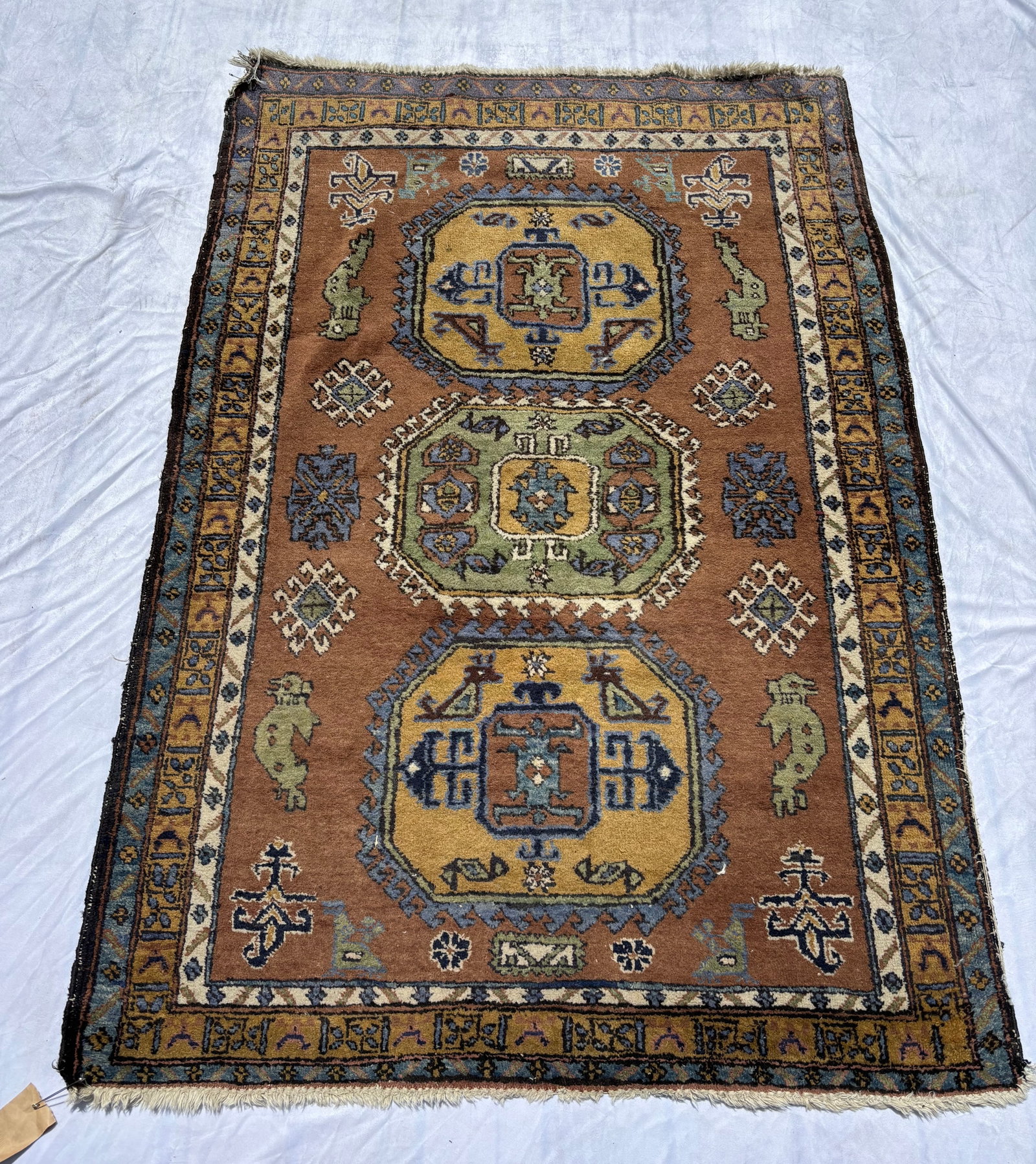 Hand-Knotted Caucasian Kazak Style Runner Rug 66 x 45 inches.: Hand-knotted Caucasian Kazak-style area rug featuring bold geometric medallions and tribal motifs in warm camel, blue, ivory, green, and gold tones. Decorative multiple borders with stylized tribal el