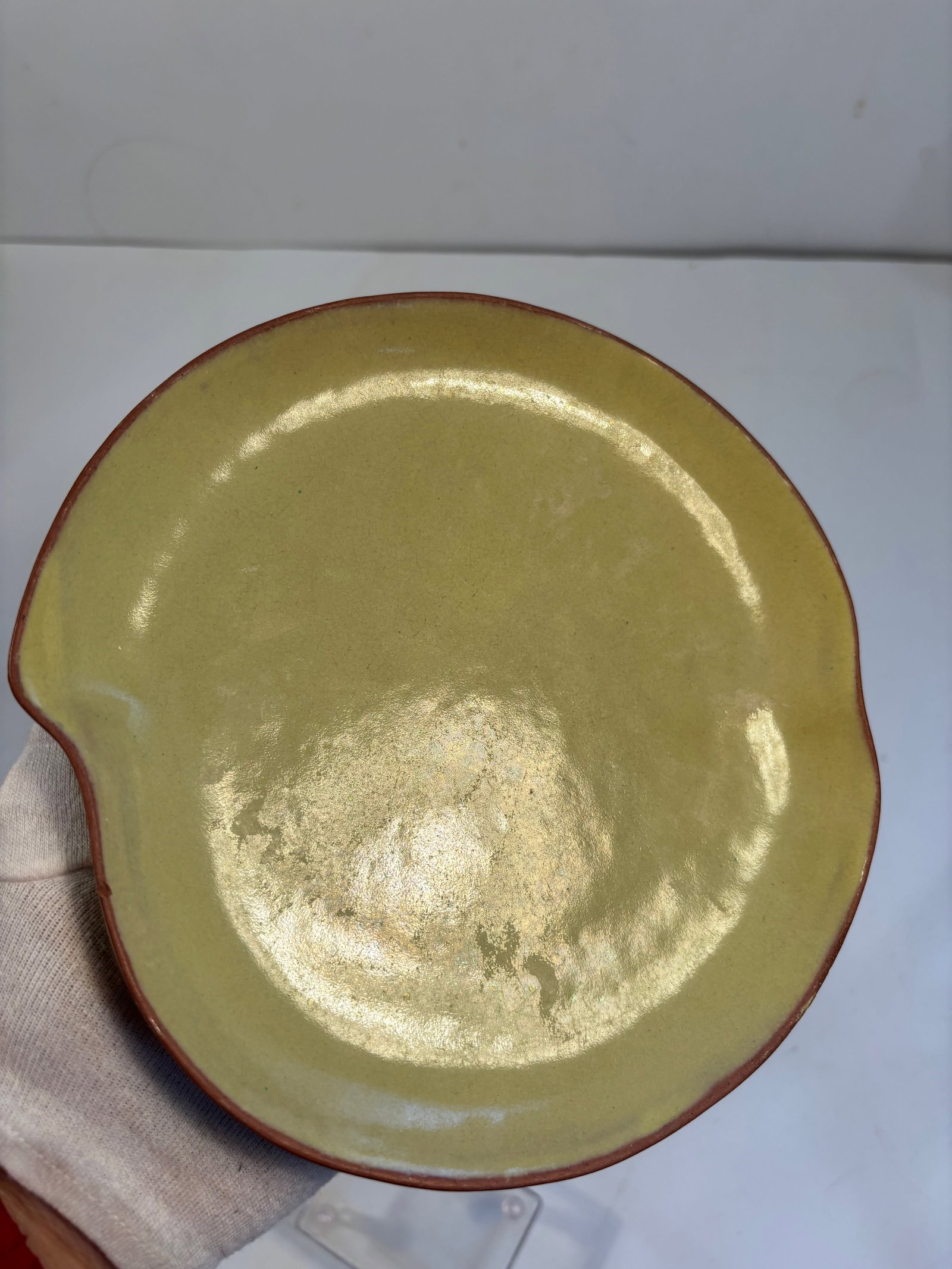 A Chinese yixing peach shape plate: Late 19th to early 20th, it could be a Republic-period scholar’s desk object, especially given the peach shape and mustard yellow glaze. Dimensions?Length/Diameter: 7.5 inches; Height: 1.25 inches.