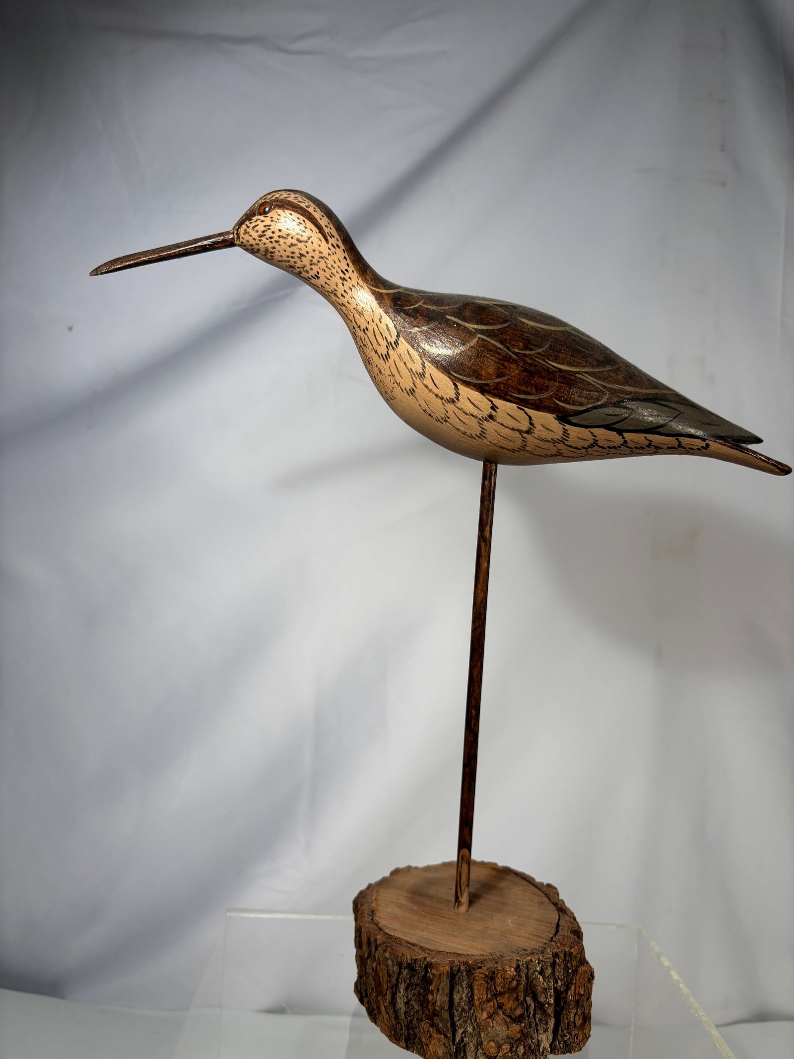 A Carved Wooden Shorebird Figure, Signed Moore: A carved wooden shorebird figure depicted standing with elongated beak and stylized body, rendered with incised and painted feather details. Signed “Moore” and dated “1901” to the unde
