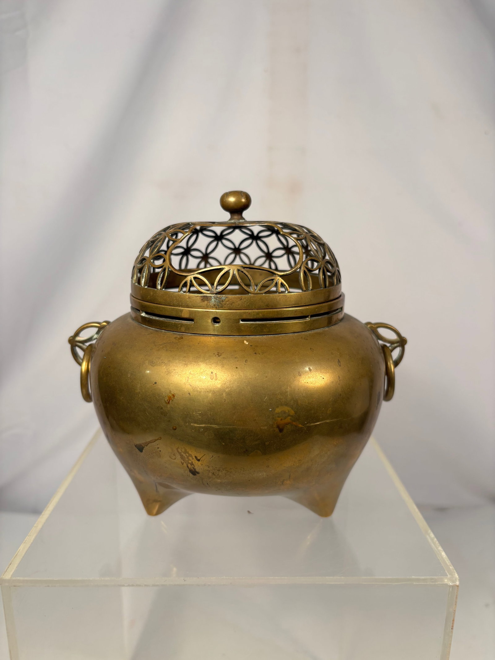 Japanese Bronze Tripod Koro Incense Burner with Reticulated Shippo Cover Meiji period (1868–1912).: An antique Japanese bronze koro incense burner dating to the Meiji period (1868–1912). The rounded peach-form body is supported on three pointed feet and fitted with a pair of loop handles suspendin