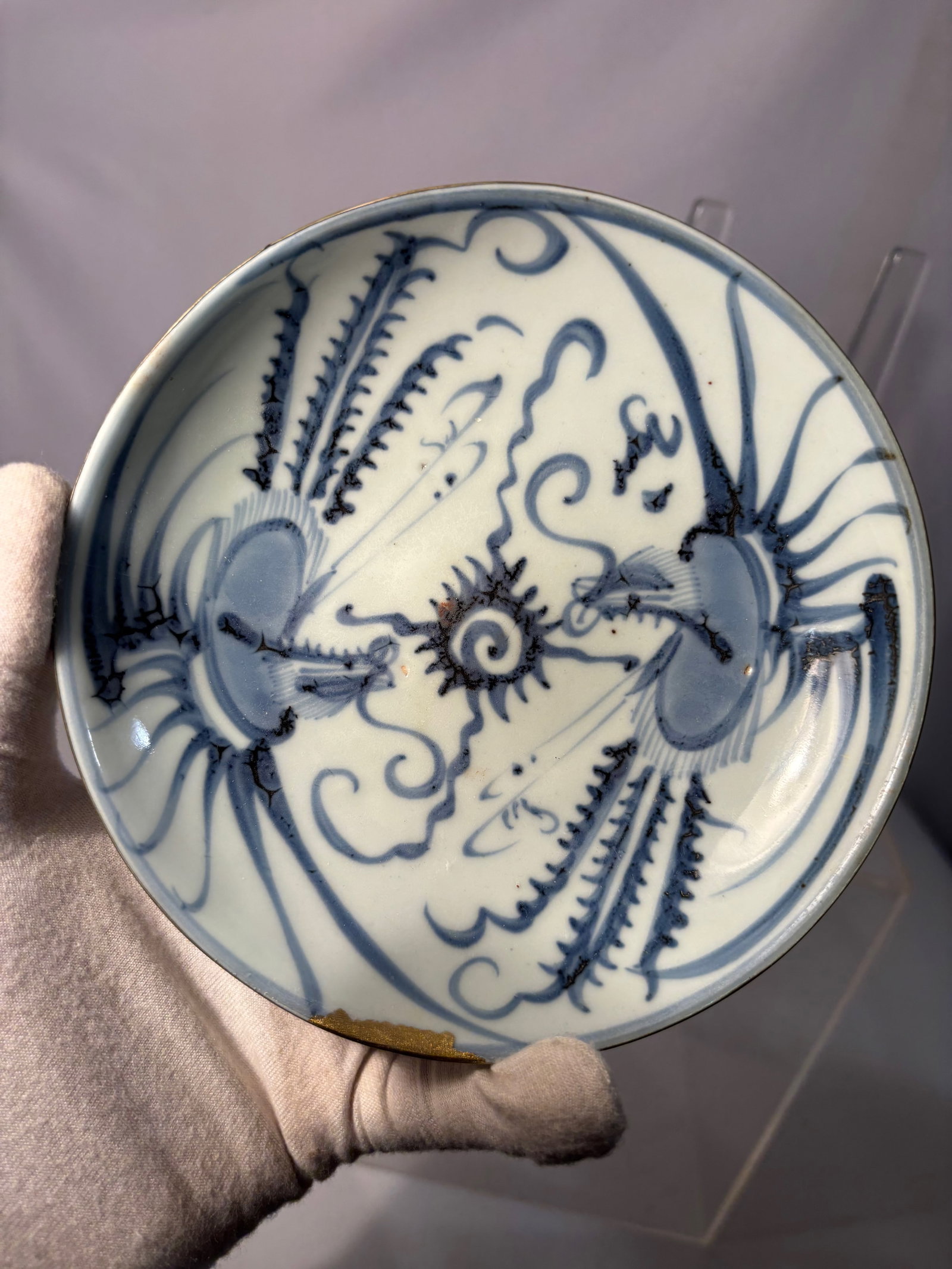 A Chinese Blue and White Dragon Plate, Possibly 17th Century: A Chinese blue and white porcelain plate decorated in underglaze cobalt with a boldly rendered dragon pursuing a flaming pearl amid scrolling cloud forms. The brushwork is expressive and fluid, charac
