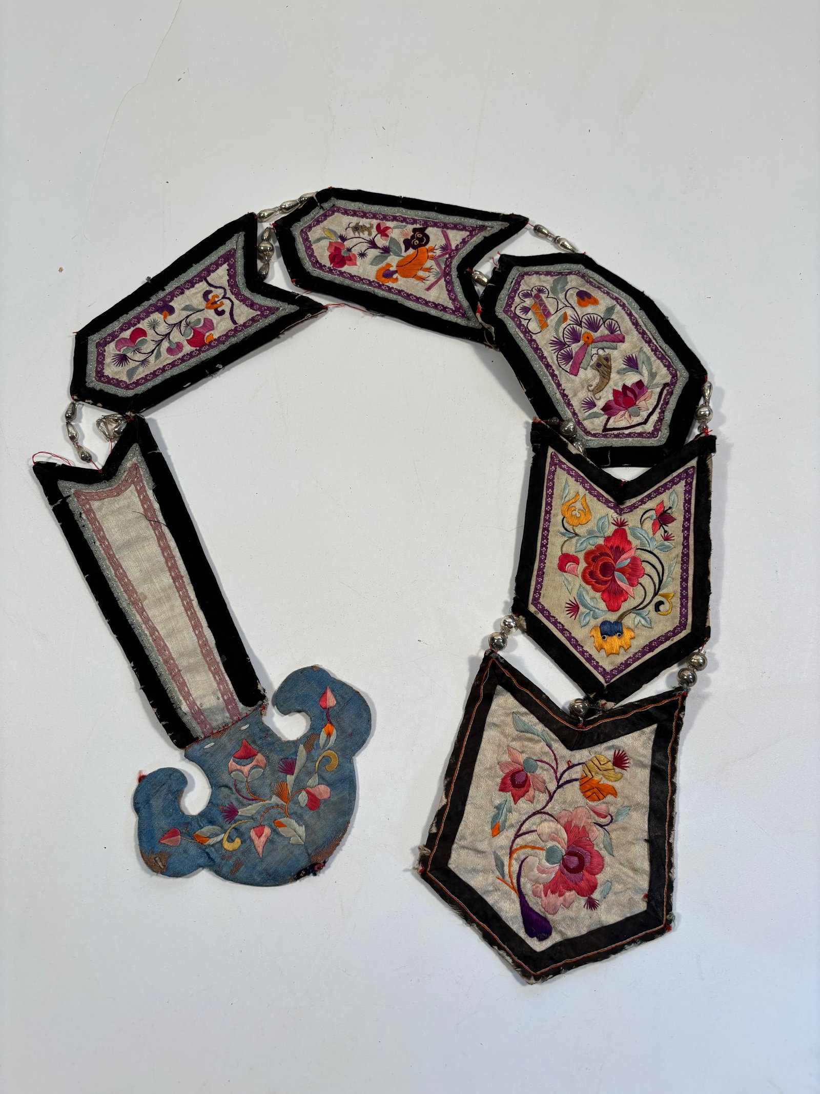 A Chinese silk embroidered ceremonial chain: 19th century;The panels feature vibrant floral embroidery, with stylized blooms, vines, and possibly auspicious fruits or animals. Dimensions?Length: 35 inches