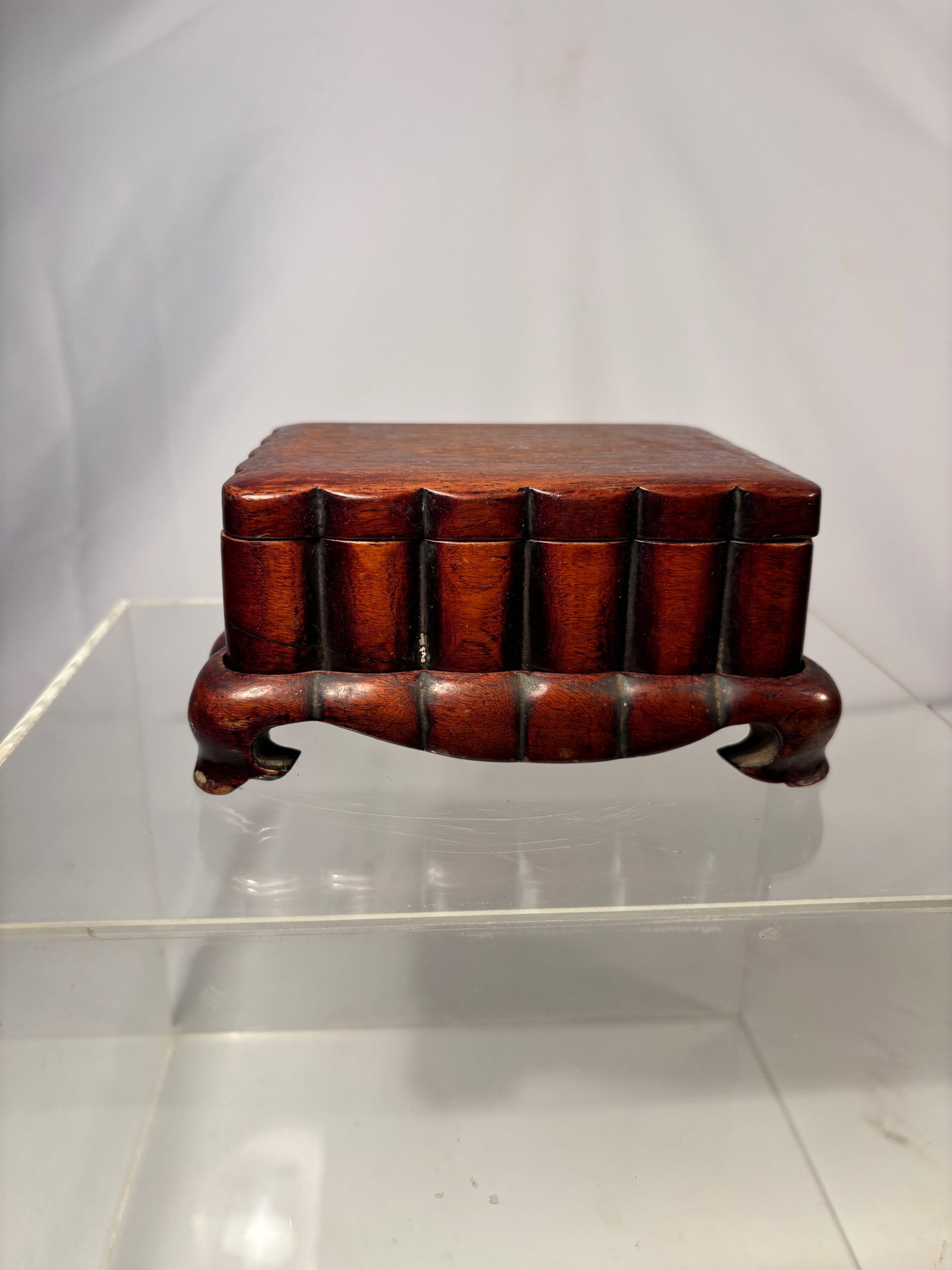 A fine Chinese hardwood/ huanghuali Scholar’s Box on Hardwood Stand: Qing dynasty(1644-1912); Rectangular Chinese hardwood/Huanghuali scholar’s box with a fitted cover, raised on a conforming openwork stand. The box features a smooth patina and well-proportioned form