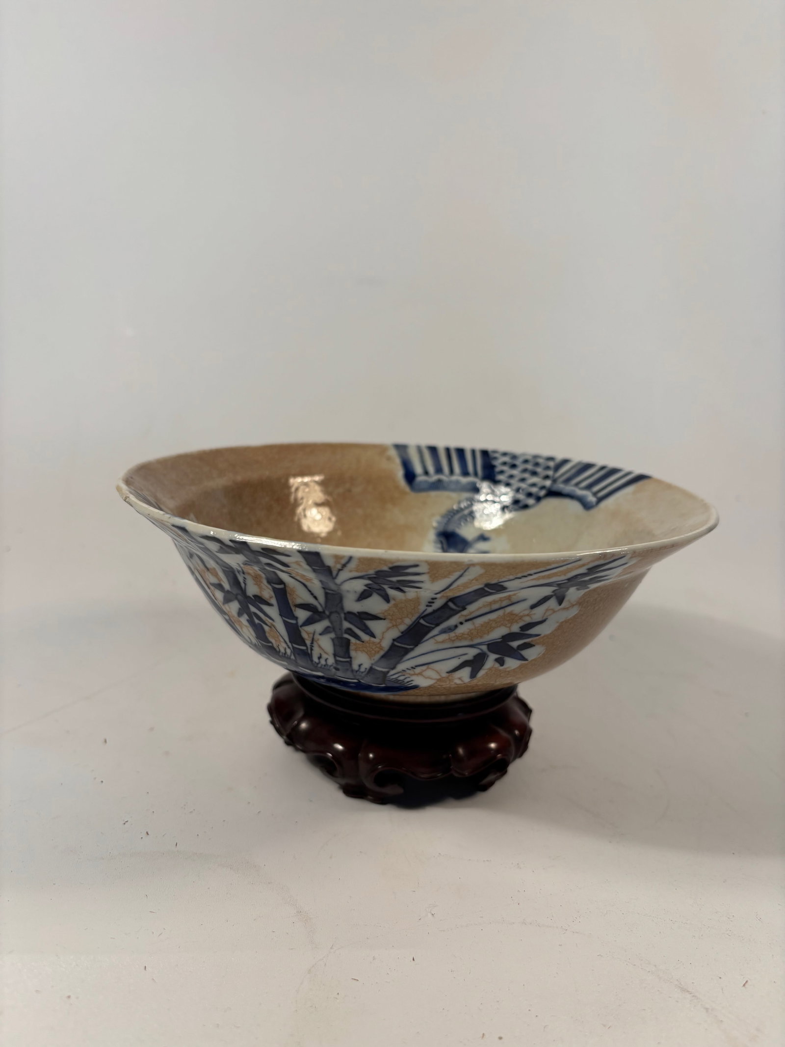 A Chinese Blue and White Crackle-Glazed Porcelain Bowl with "XUAN DE" MARK: Kangxi period(1662-1722); Deep conical form with a slightly everted rim, the interior and exterior are decorated in underglaze cobalt blue with finely painted bamboo, a phoenix in flight, and a centra