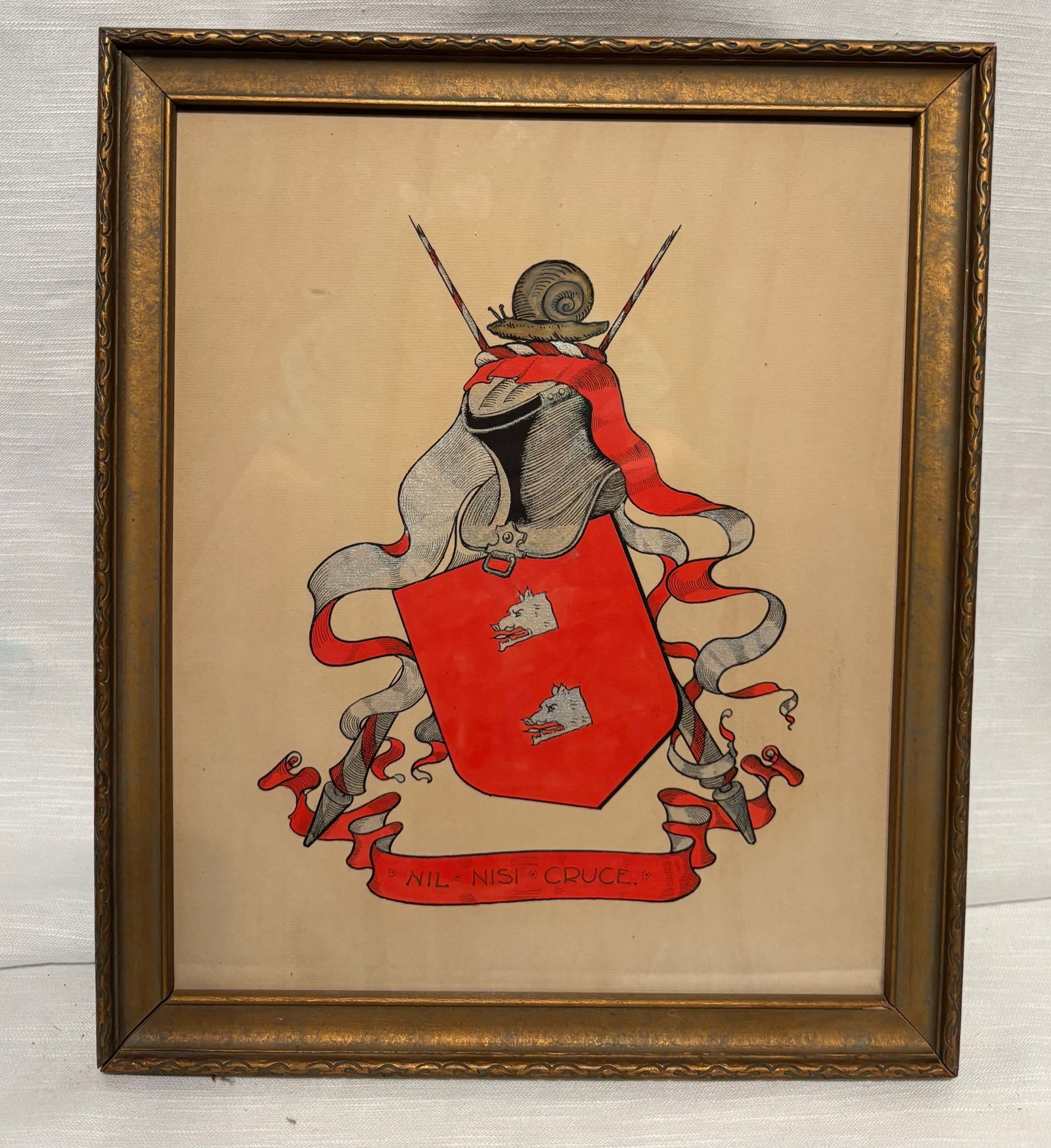 Framed Heraldic Coat of Arms Painting, Latin Motto “Nil Nisi Cruce??, Vintage Decorative Crest: A framed heraldic coat of arms painting featuring a red shield with stylized devices, helmet crest, and flowing mantling. The banner below bears the Latin motto “Nil Nisi Cruce” (“Nothing bu