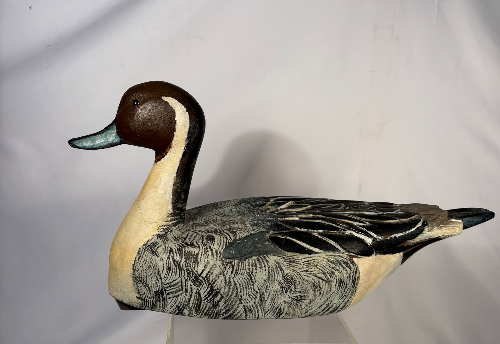 An Large American Hand-Carved Painted Duck Decoy, Mid-20th Century: An American hand-carved and painted duck decoy, mid-20th century, by Ray Christen. The solid carved body is realistically modeled with painted feather detail and a carved head with glass eyes. The und