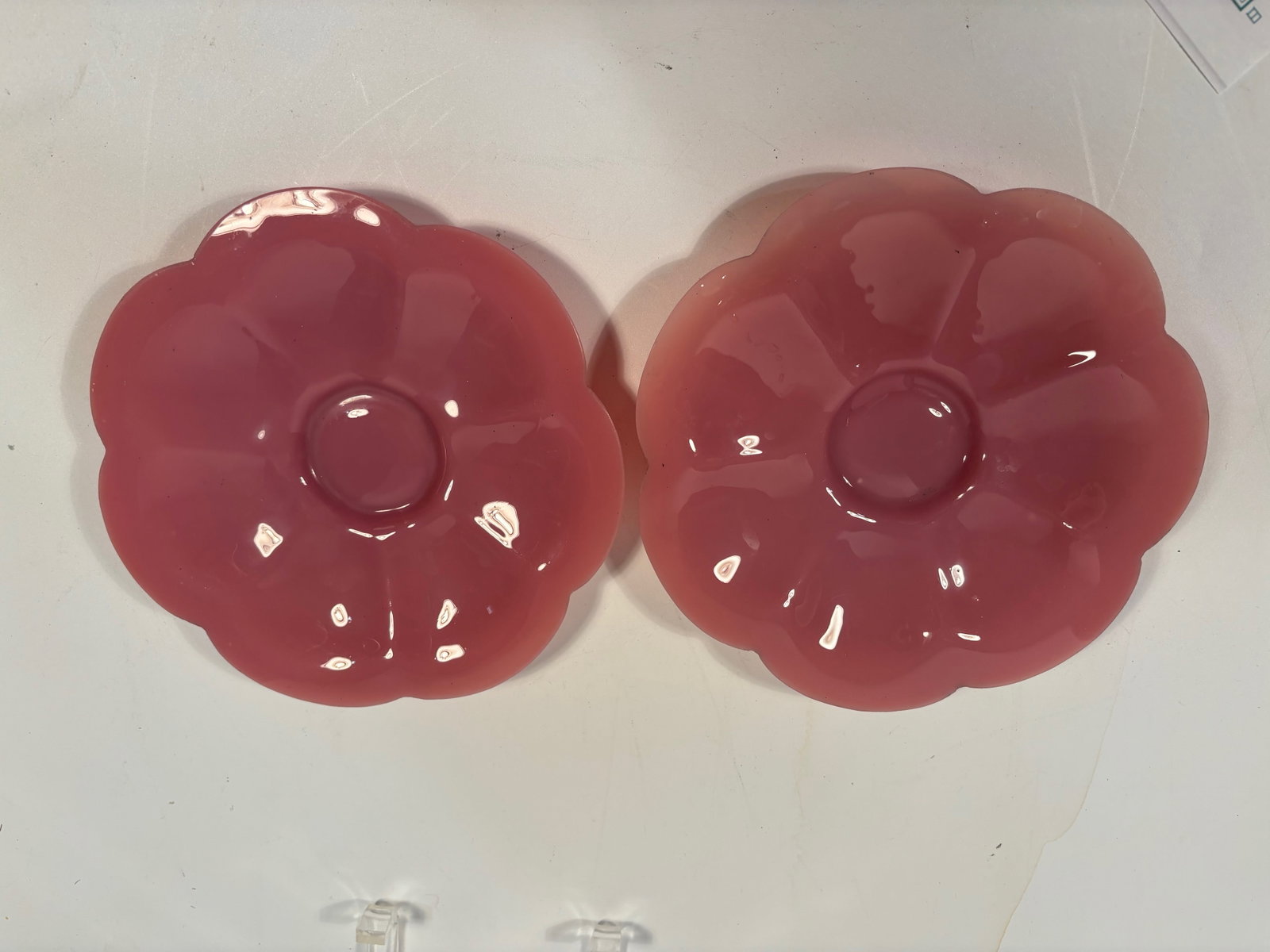 A paif of Chinese pink flower shape PEKING glass with MARK: Qing Dynasty (1644-1912). Rich color a, polished , smooth surface, has a carved "CHINA" mark at the bottom. Dimensions?Diameter: 7.25 inches; Height: 1 inch.