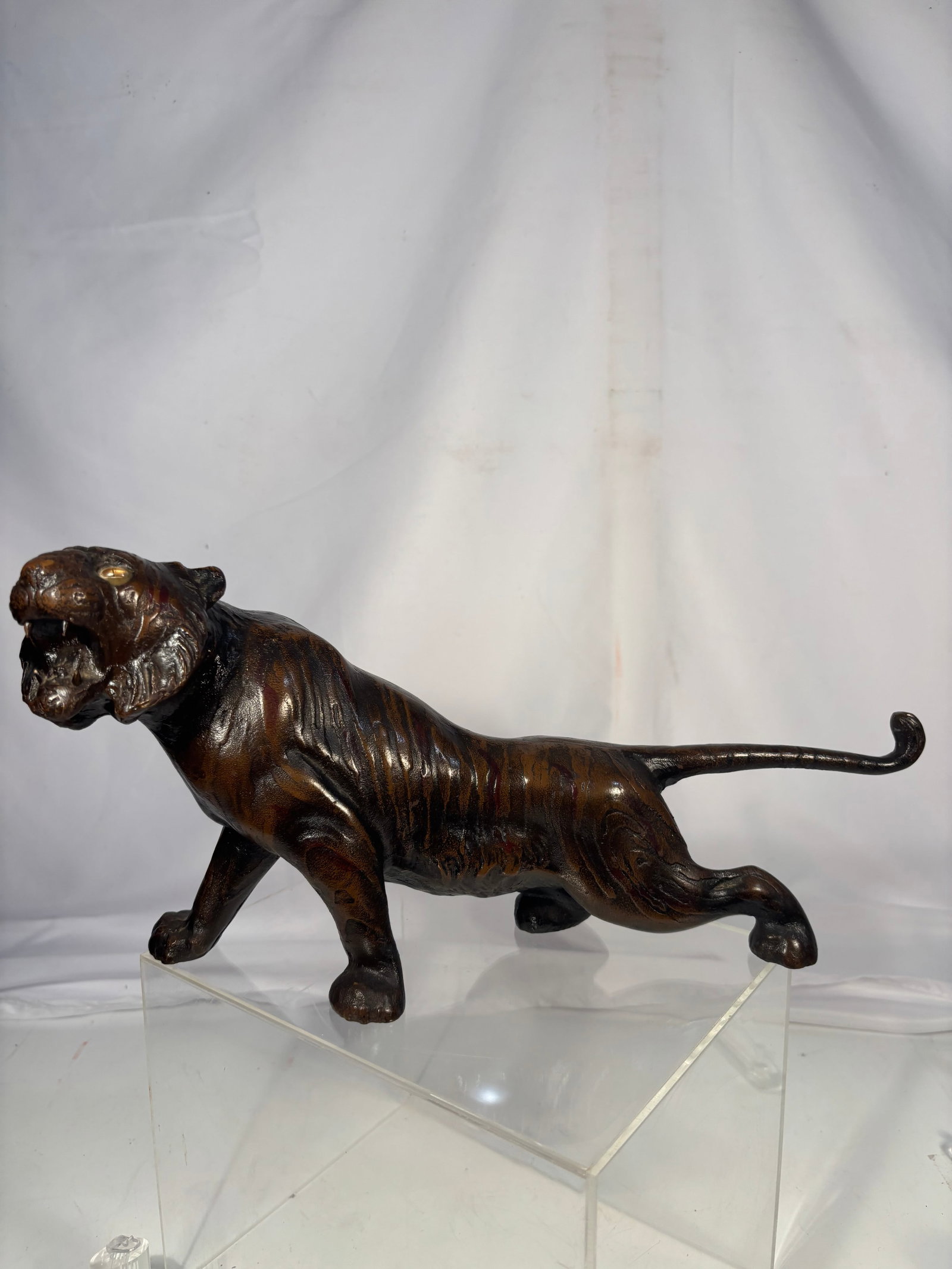 A Japanese Bronze Tiger with Glass Eyes, Meiji period: Japanese bronze tiger sculpture, Meiji period (1868–1912), modeled in a prowling stance with open mouth and inset glass eyes. Finely cast with detailed musculature, expressive facial features, and n