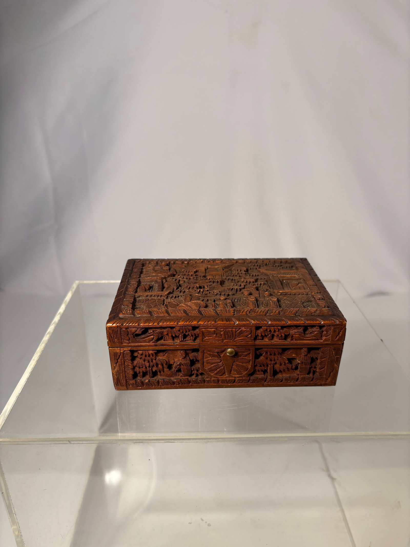 A Chinese Hand-Carved Sandalwood Figural Box: Qing dynasty(1644-1912) ; A finely hand-carved Chinese sandalwood box, decorated in deep relief with an elaborate landscape and architectural scene. The lid features multi-layered carvings of pavilion