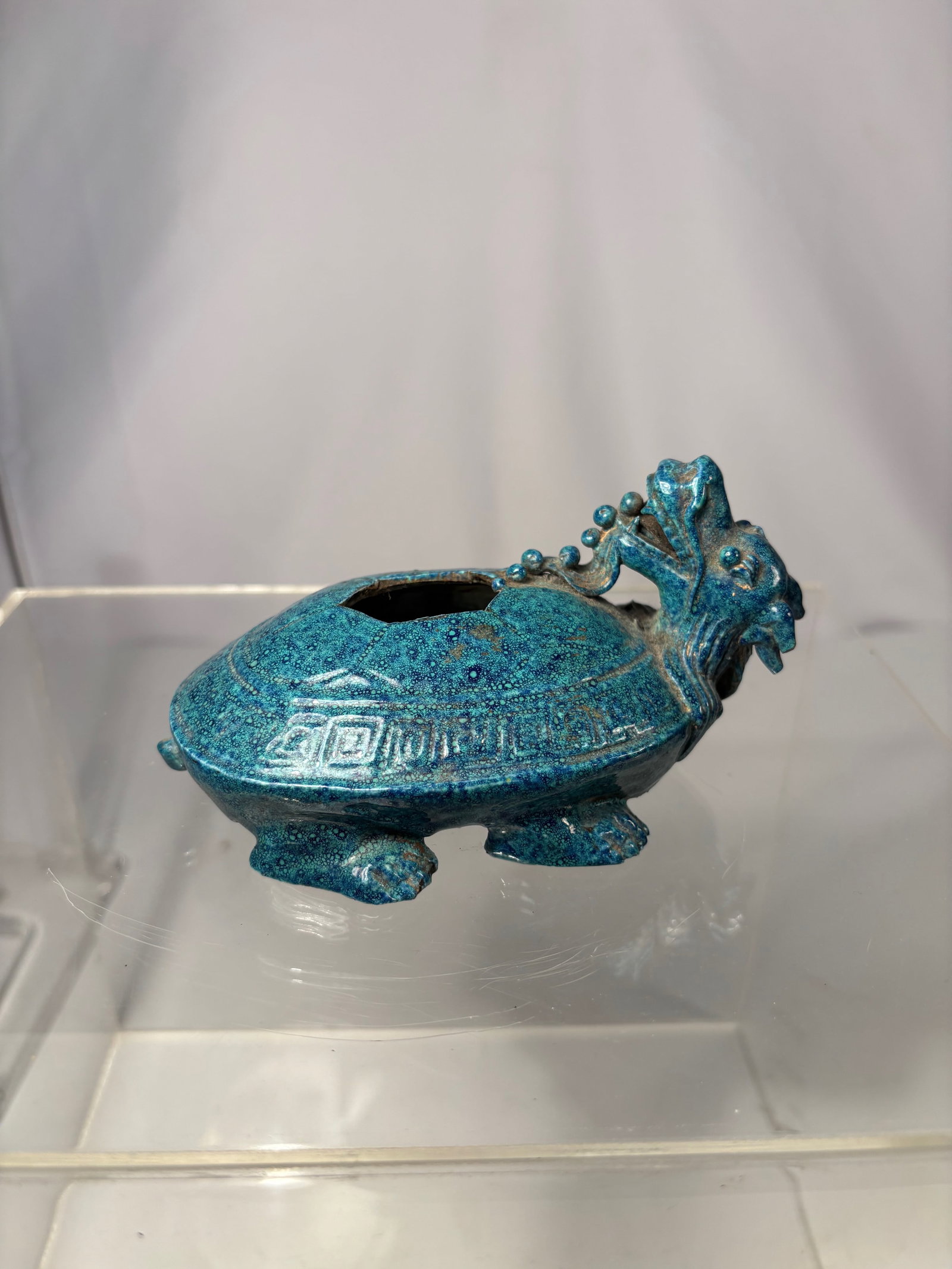 A Chinese Robin’s Egg Turquoise-Glazed Dragon-Turtle Censer: Qing dynasty(1644-1912) ; A boldly modeled Chinese ceramic censer in the form of a mythical dragon-turtle (longgui), covered overall in a vibrant Robin’s Egg blue glaze. The glaze displays the chara
