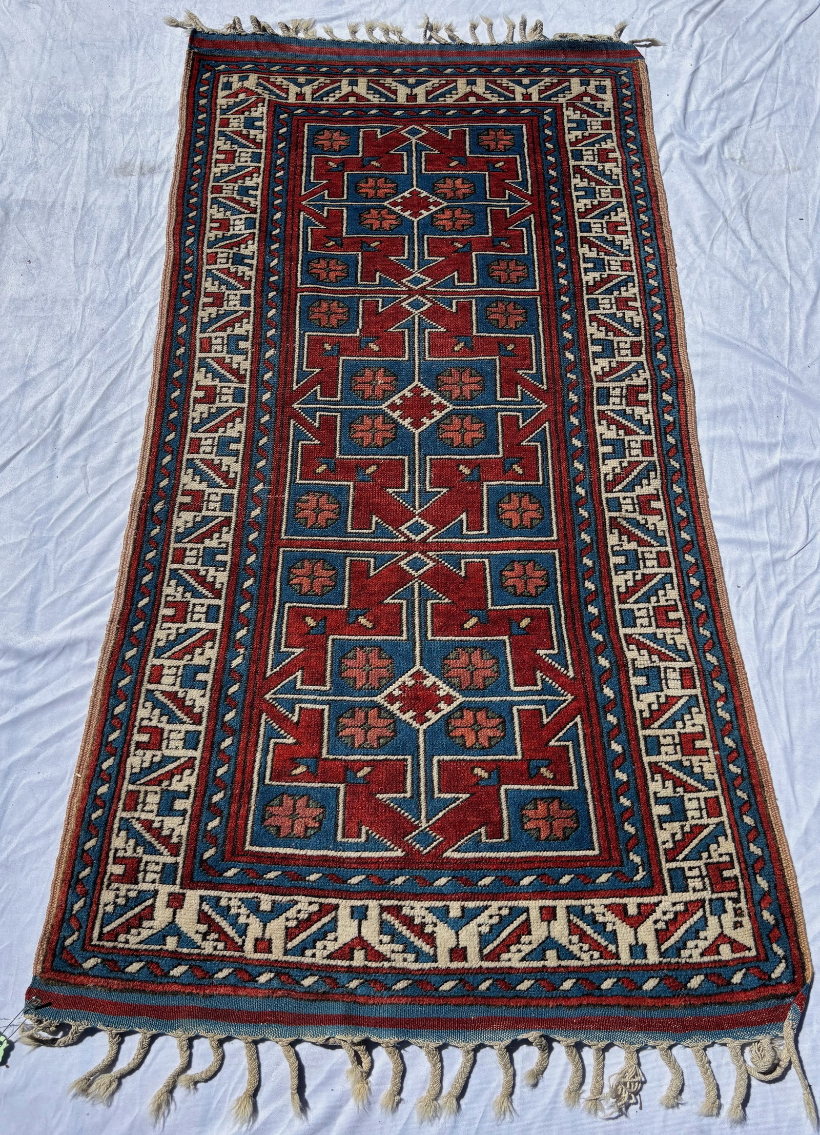 Caucasian Style Geometric Runner Rug 77 x 37 in.: Hand-knotted wool runner featuring bold geometric medallions in vivid red, blue, and ivory tones with angular border motifs in the Caucasian tradition. Strong visual contrast and tribal-inspired desig