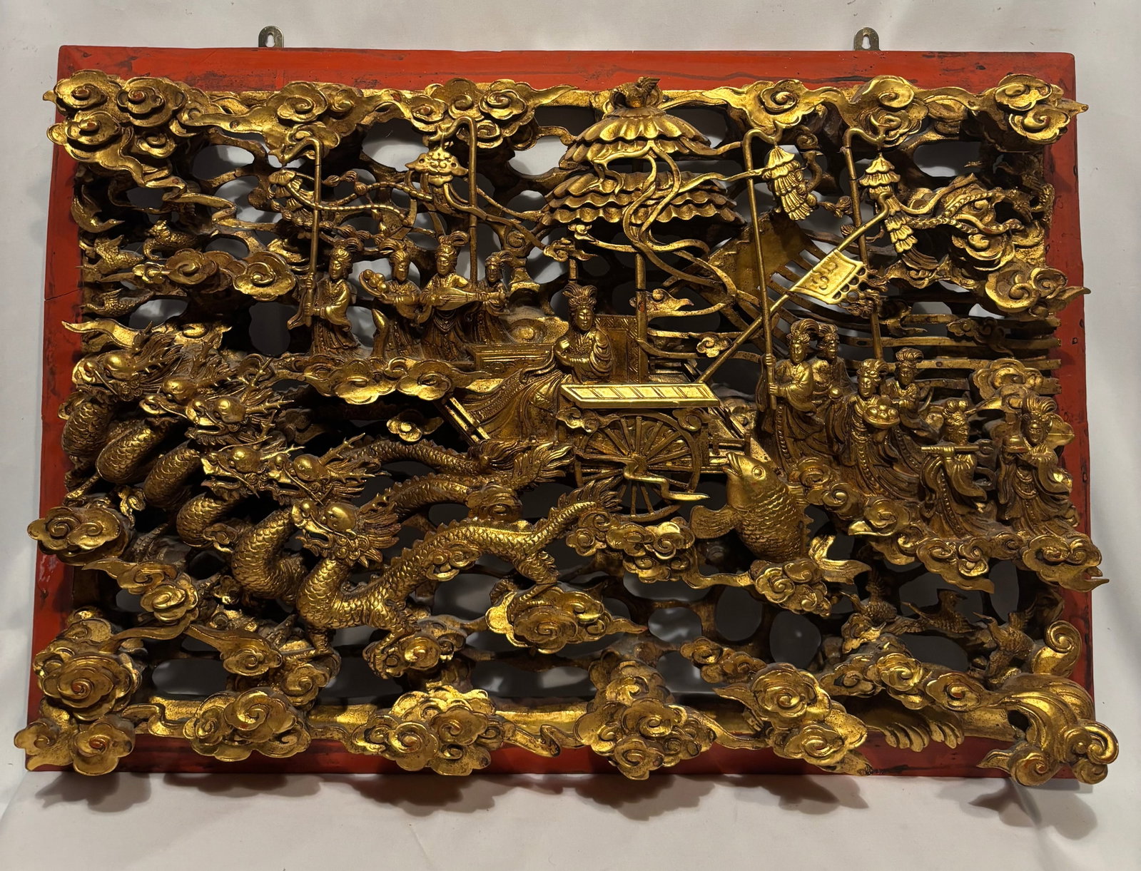 Large Chinese Gilt Carved Openwork Dragon & Court Ladies Wall Panel: Large Chinese gilt carved openwork wood wall panel depicting an elaborate auspicious scene with dragons emerging from swirling clouds, elegant court ladies, attendants, cranes, koi fish, a scholar’s