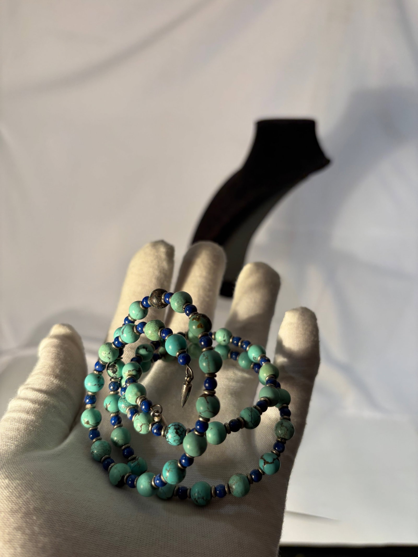 A Turquoise and Lapis Lazuli Bead Necklace / Wrap Bracelet: Strand composed of natural turquoise beads displaying varied blue-green tones with matrix veining, accented by deep blue lapis lazuli spacer beads and metal separators. Length: 24 inches.
