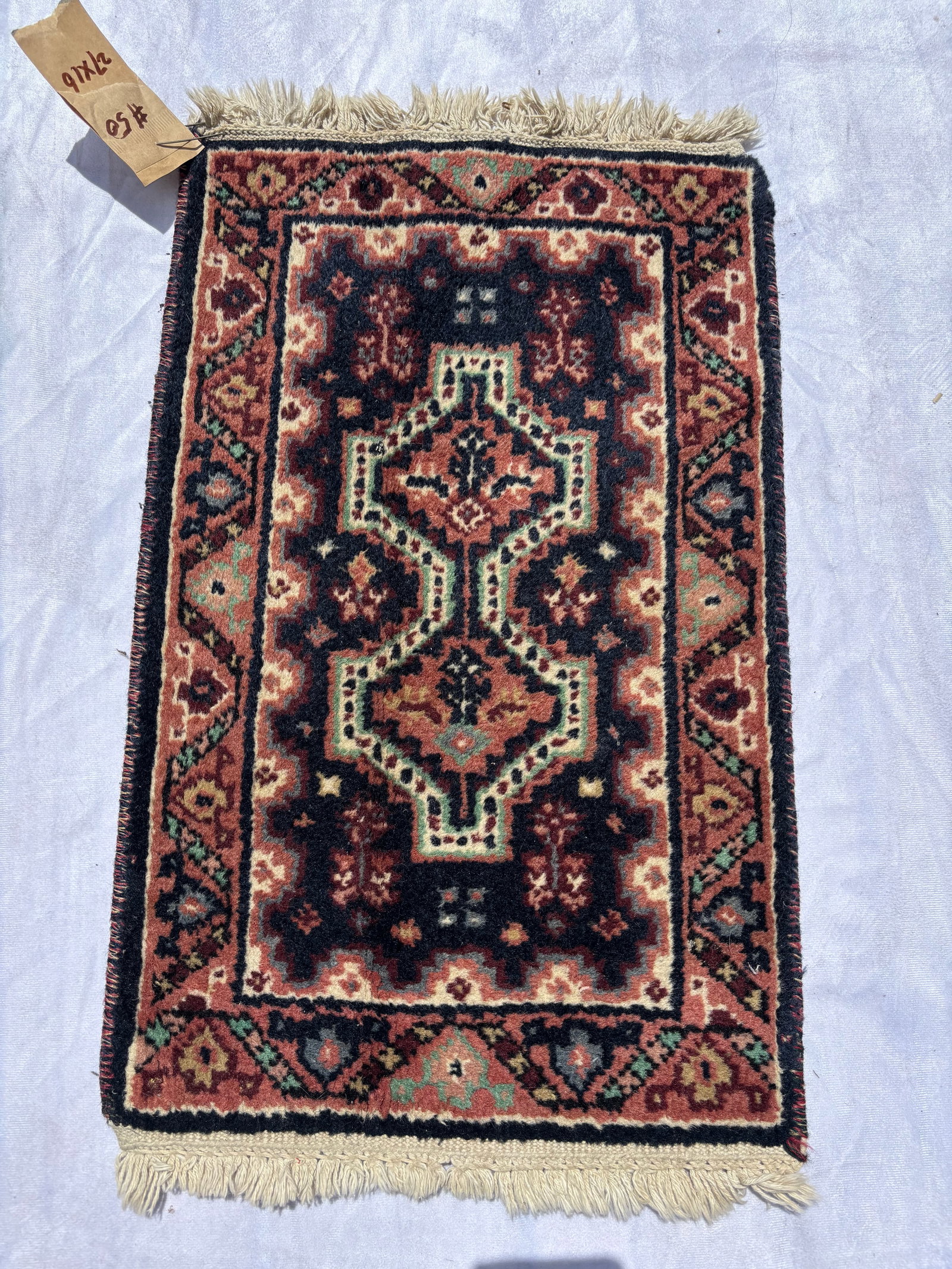 Antique Persian Hamadan Style Hand-Knotted Rug, 27 x 16 In.: Hand-knotted wool rug featuring geometric medallions on a dark field with traditional Persian village motifs and decorative borders. Measures approximately 27 x 16 inches. Inventory #50 .