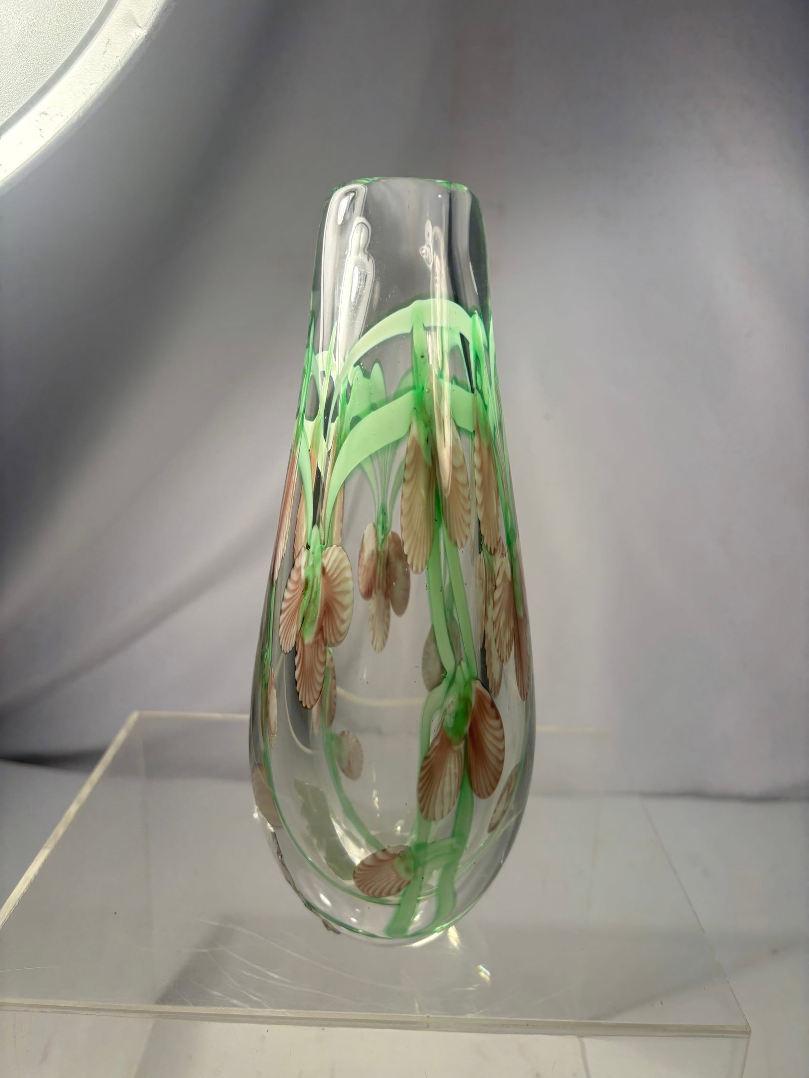 Vintage Murano-Style Art Glass Vase with Encased Floral Decoration: A handblown clear art glass vase of elongated teardrop form, decorated with internally encased green stems, leaves, and brown-and-white flowers. The substantial body has a thick rounded base and polis