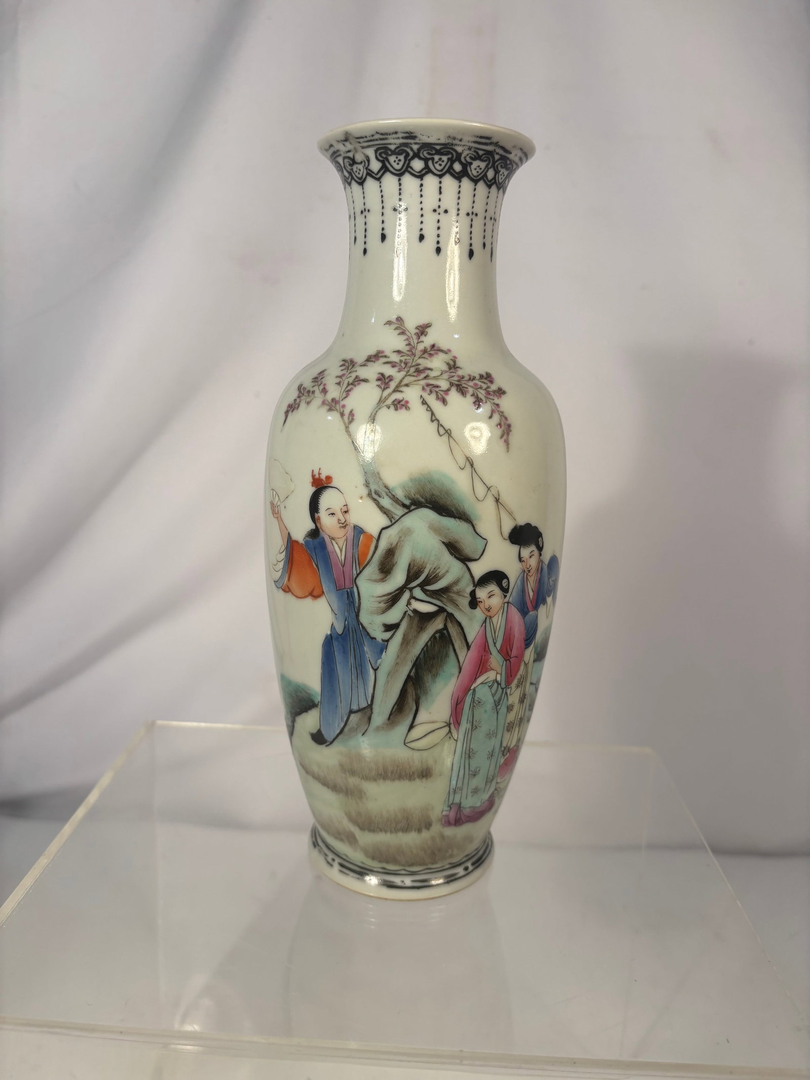 Chinese Famille Rose Porcelain Vase with Figures, Qianlong Mark, Republic Period: A Chinese porcelain baluster vase decorated in famille rose enamels with elegant figures gathered beneath a flowering tree and ornamental rockwork. The flared neck features a dark decorative border wi