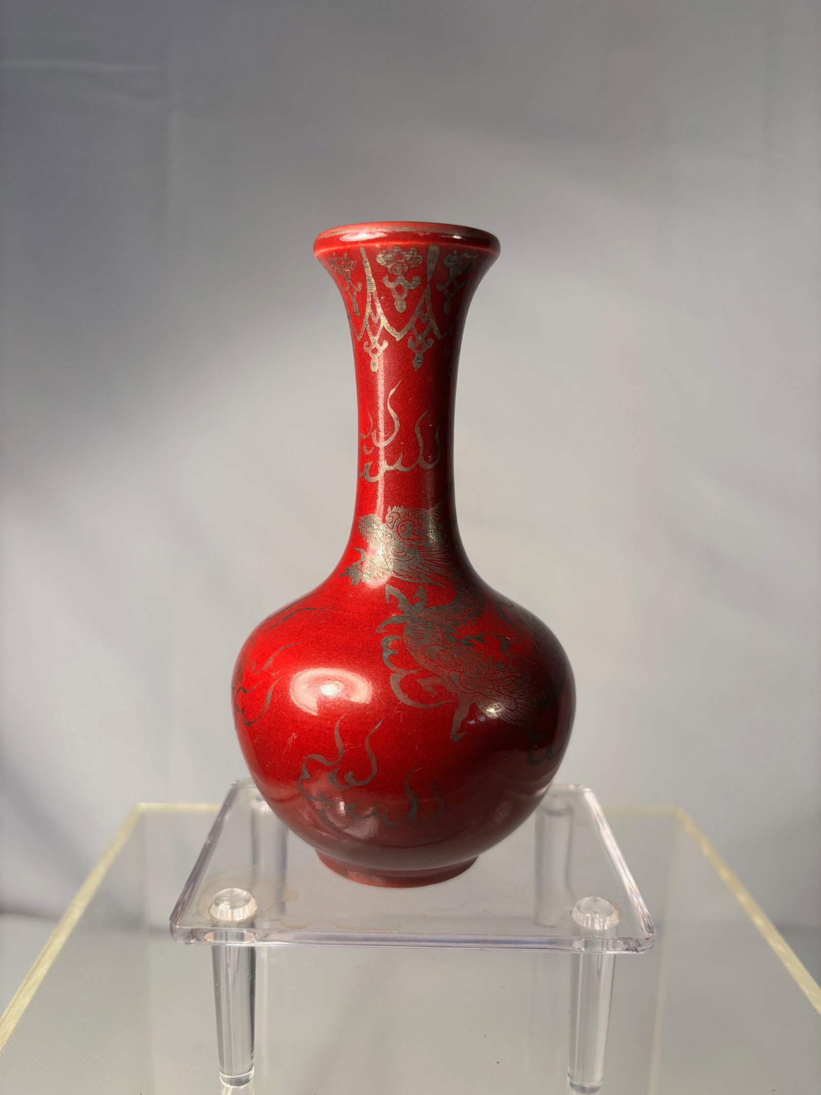 A Japanese Red Overlay Glass Vase with Dragon Motif: Early 20th century, A small Japanese red overlay glass vase, the globular body tapering to a slender flared neck, decorated with an engraved dragon in pursuit of the flaming pearl among stylized cloud