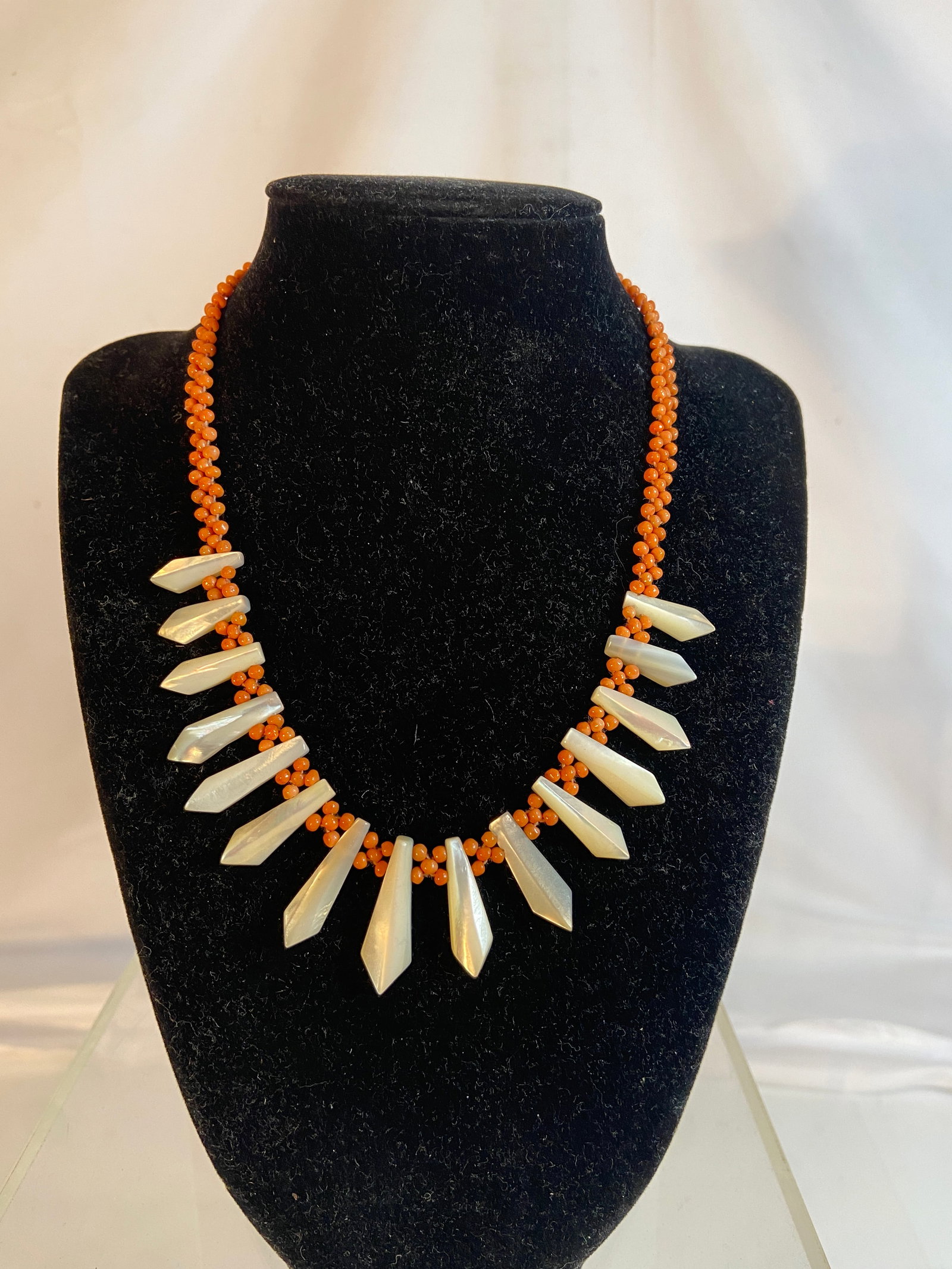 Vintage Coral Bead and Mother-of-Pearl Necklace: Vintage necklace composed of multi-strand coral beadwork accented with carved mother-of-pearl pendants in a graduated radiating design. Finished with a gold-tone clasp. Length: 16 inches.