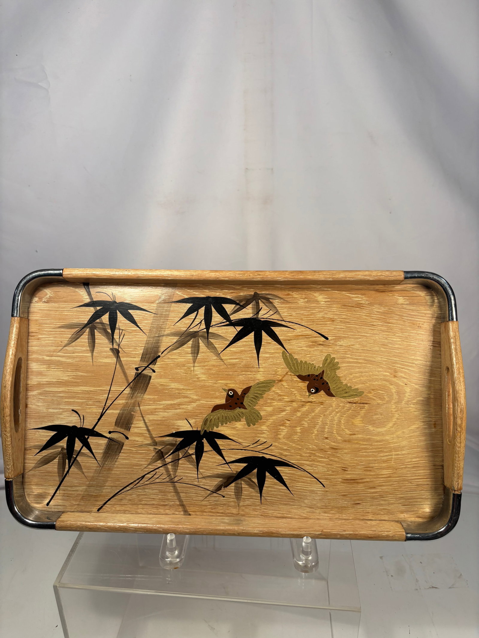 A Japanese Bamboo and Bird Decorated Wooden Serving Tray, Mid-Century: Japanese mid-century wooden serving tray decorated with bamboo stalks and flying birds. Featuring integrated side handles with metal corner supports. Likely produced for export during the mid-20th cen