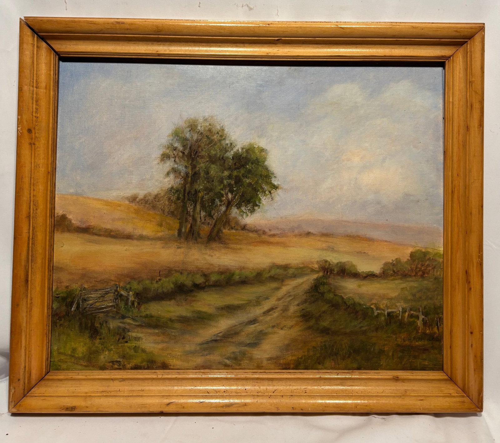 Signed Landscape Oil Painting on Canvas: Original oil on canvas depicting a tranquil rural landscape with a winding country road, open fields, and mature trees beneath a soft blue sky. Executed in natural earth tones with delicate brushwork 
