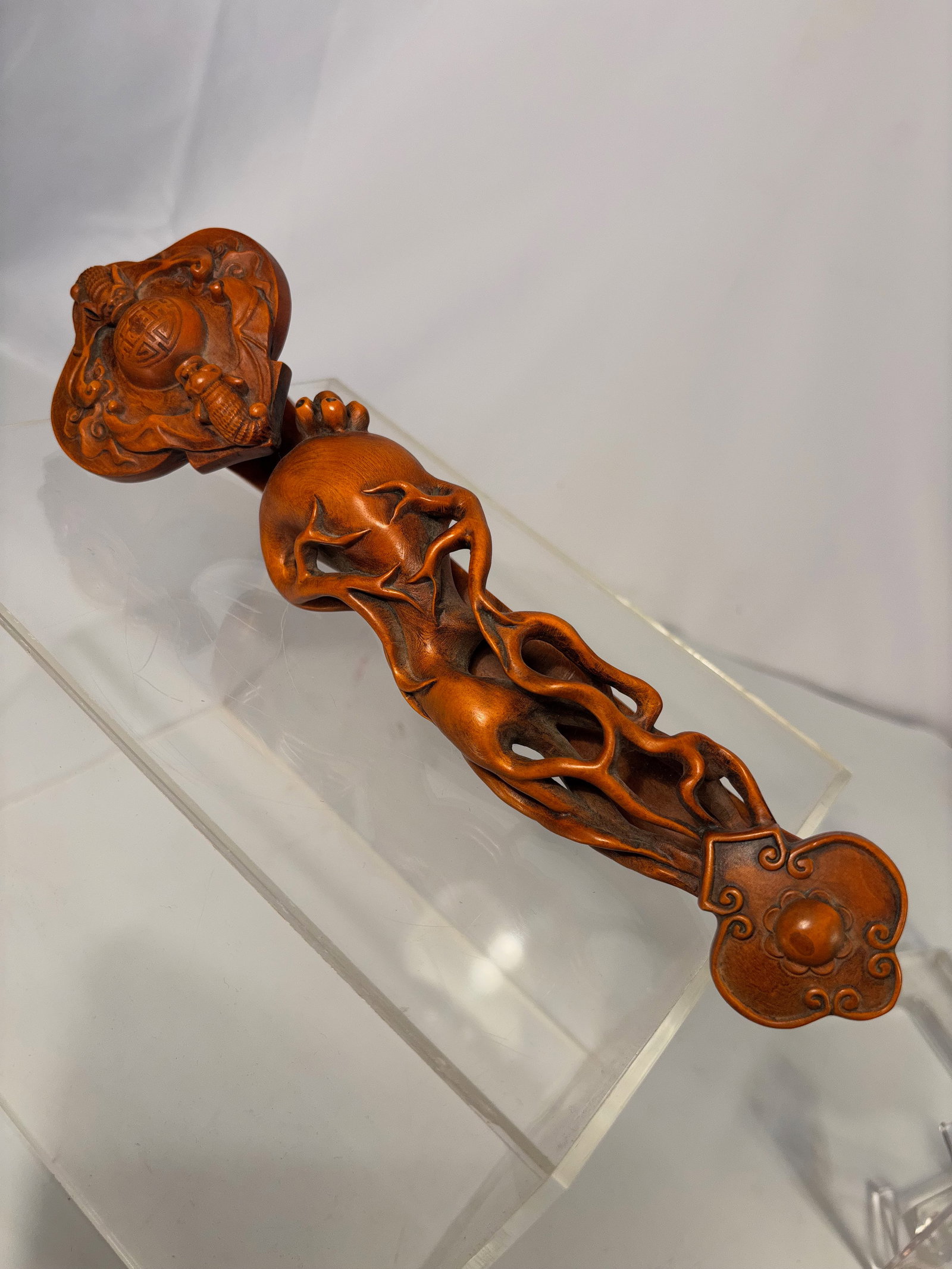 A Chinese Carved Boxwood Ruyi Scepter: Carved boxwood ruyi scepter, the handle worked in openwork with scrolling vine motifs and pierced decoration, terminating in a ruyi-head carved with auspicious symbols including a longevity medallion,