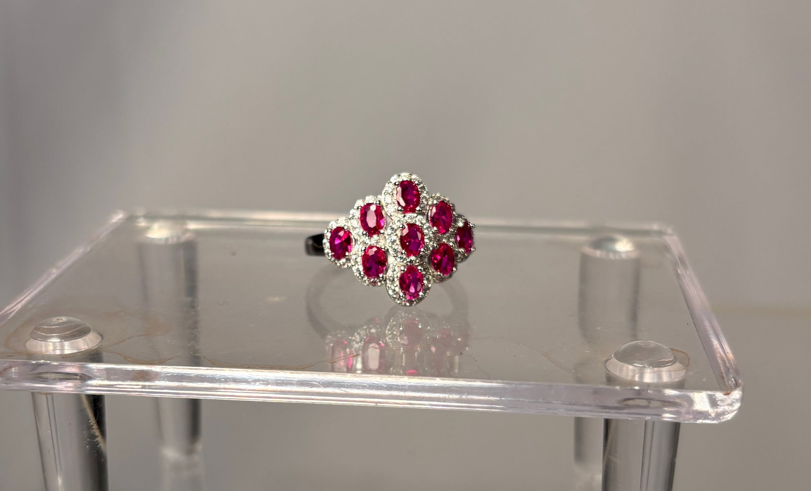 A Sterling Silver (925) Ring with Ruby: A sterling silver ring marked 925, set with a faceted ruby. The ruby displays a deep red tone with natural inclusions visible under magnification, consistent with genuine ruby. The silver mount is sim