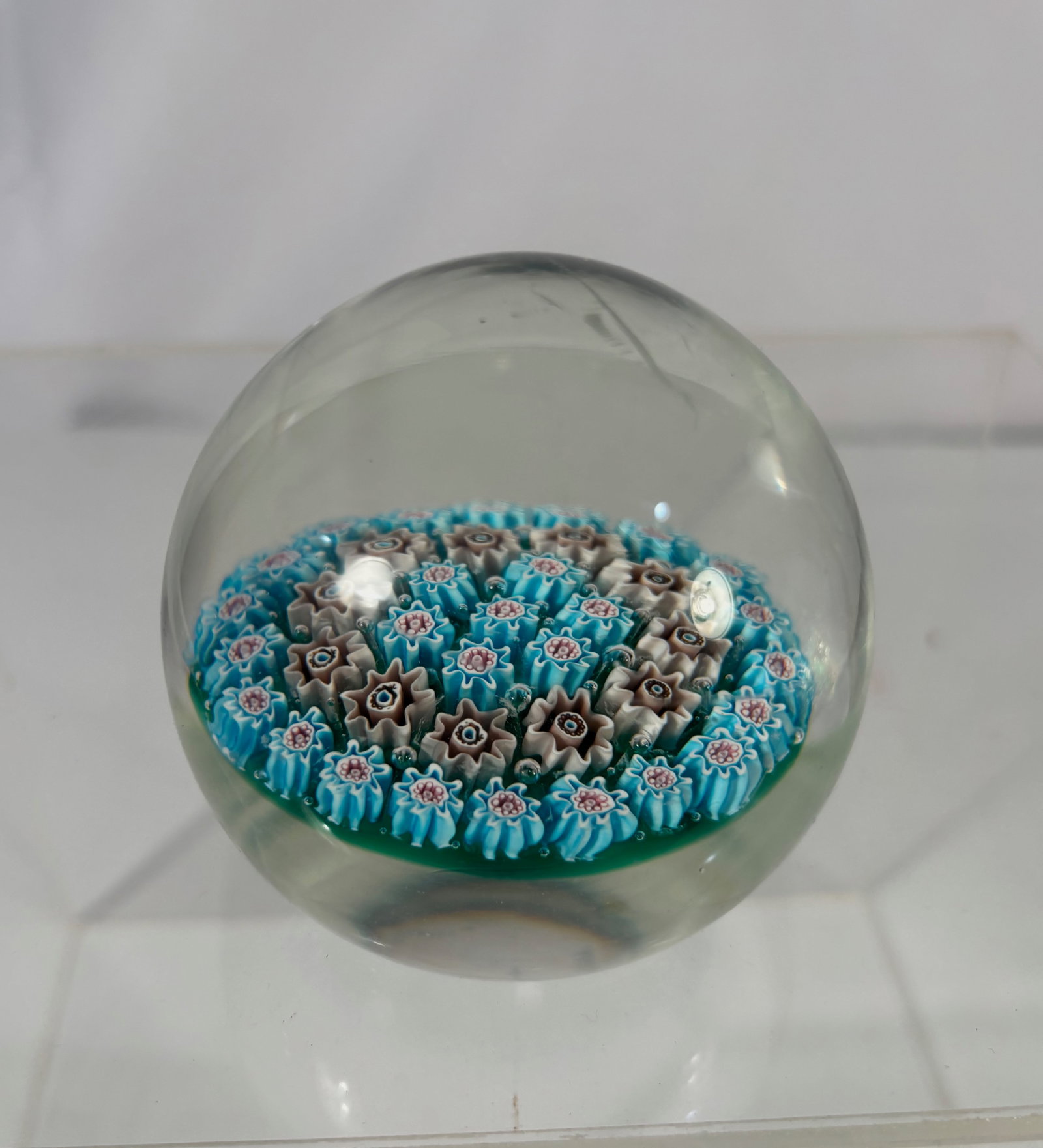 Art Glass Millefiori Paperweight with Multicolor Floral Canes: Art glass millefiori paperweight featuring a dense arrangement of multicolor floral canes in shades of turquoise blue, white, pink, and brown, set beneath a clear glass dome. The canes are well define