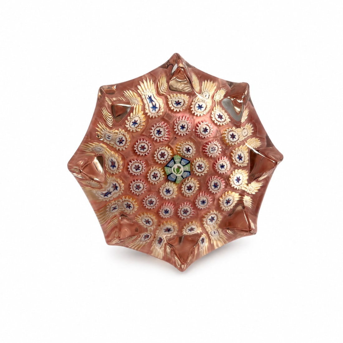 John Deacons Scottish Faceted Closepack Millefiori Glass Paperweight: A handcrafted Scottish art glass paperweight by John Deacons, featuring a close-packed millefiori arrangement over a warm pink ground. The design is composed of concentric rows of colorful cog and sta