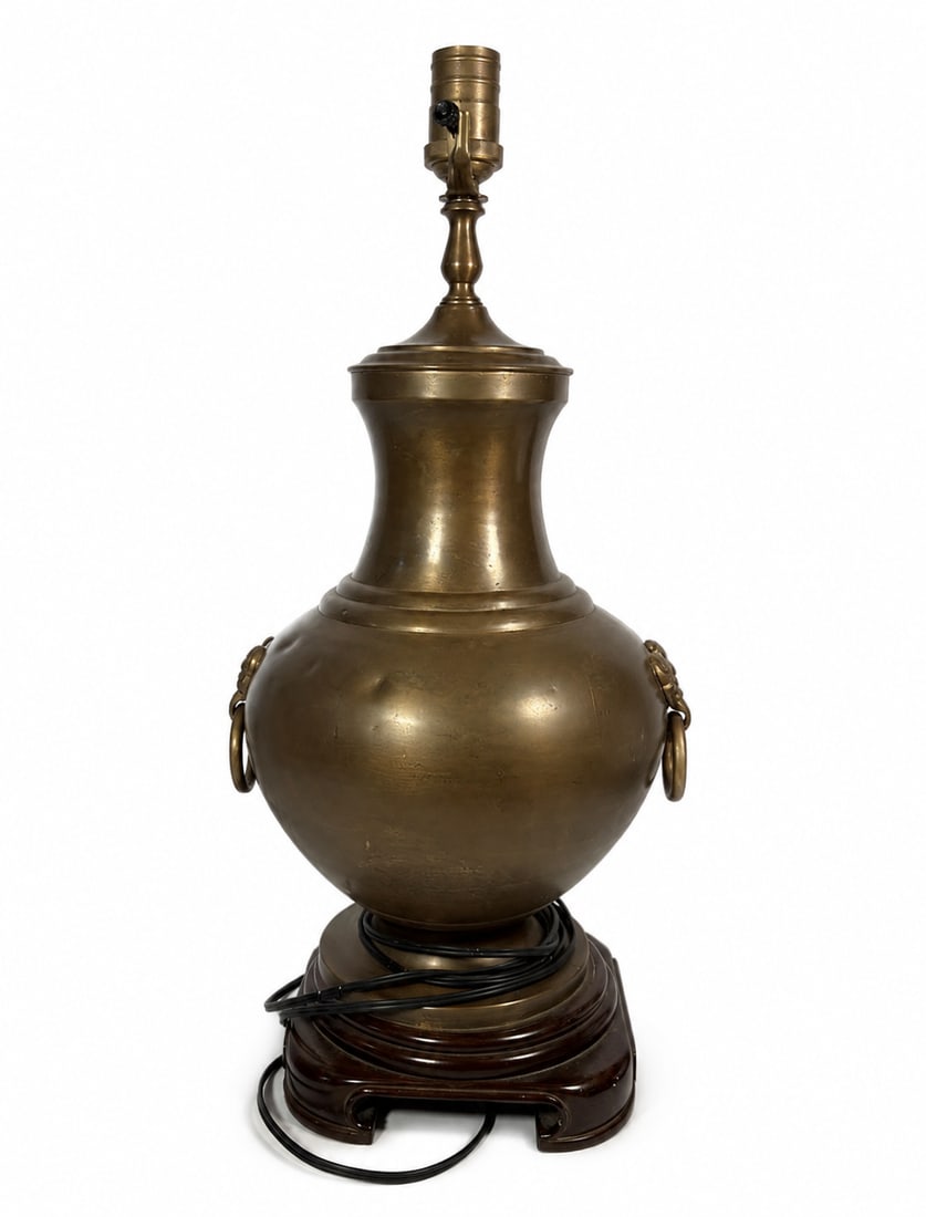 Chinese Brass Urn-Form Table Lamp with Ring Handles: A vintage brass table lamp fashioned in the form of an Asian-style urn, featuring a rounded body, tall flaring neck, and a pair of loose ring handles suspended from decorative mask-form mounts. The ve