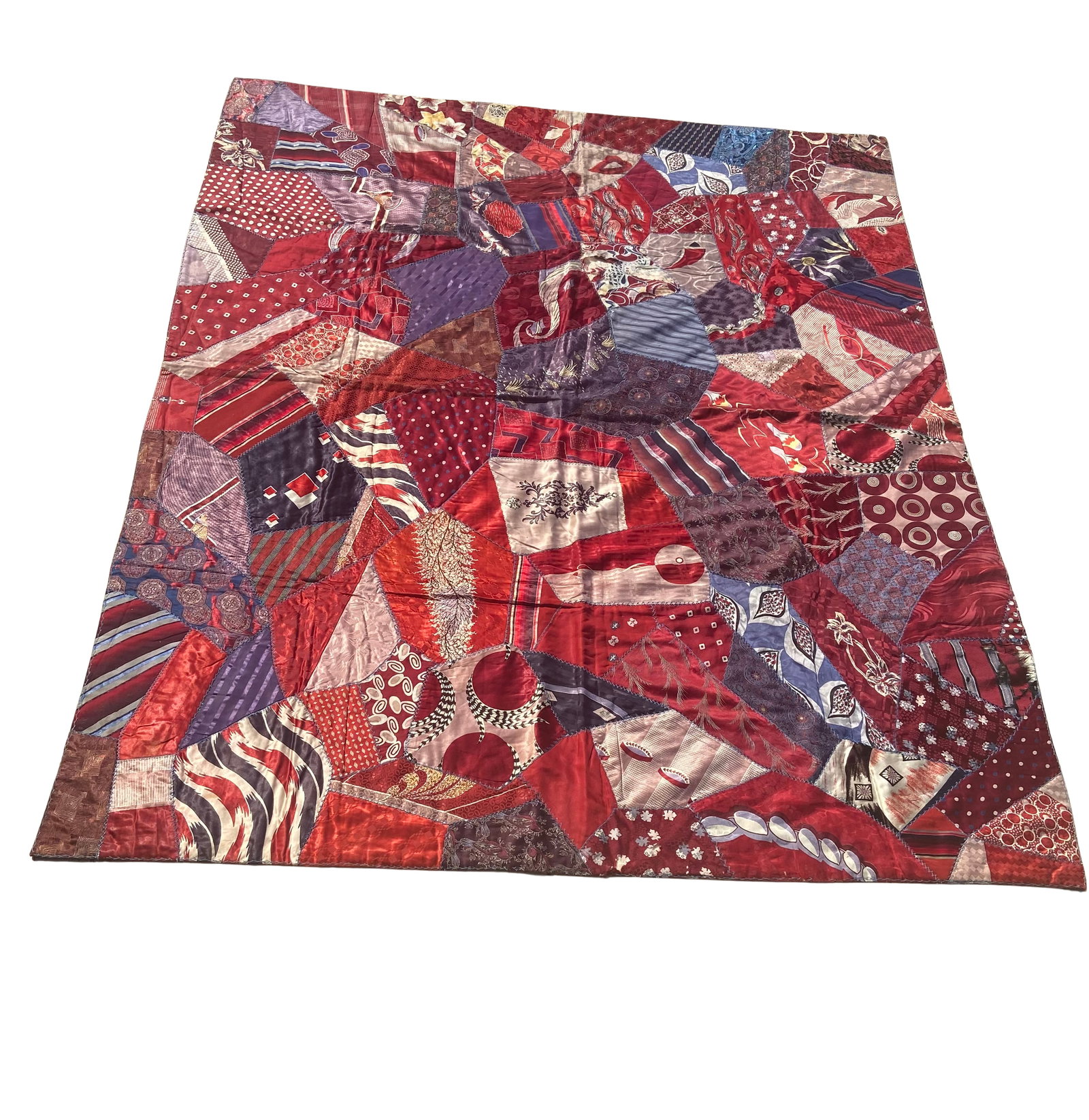 Vintage Handmade Crazy Quilt, Red & Purple Silk Patchwork Folk Art Textile: This vintage handmade crazy quilt features an expressive patchwork design composed of irregularly shaped silk and satin fabric pieces in rich tones of red, burgundy, and purple. The composition showca