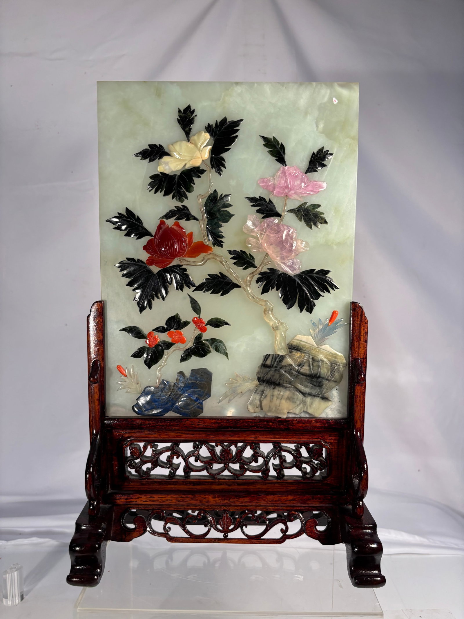 Chinese Hardstone & Coral Floral Table Screen on Carved Hardwood Stand: Chinese decorative hardstone table screen featuring an elegant floral arrangement crafted from carved coral blossoms, rose quartz flowers, dark green hardstone leaves, and other semi-precious stone el