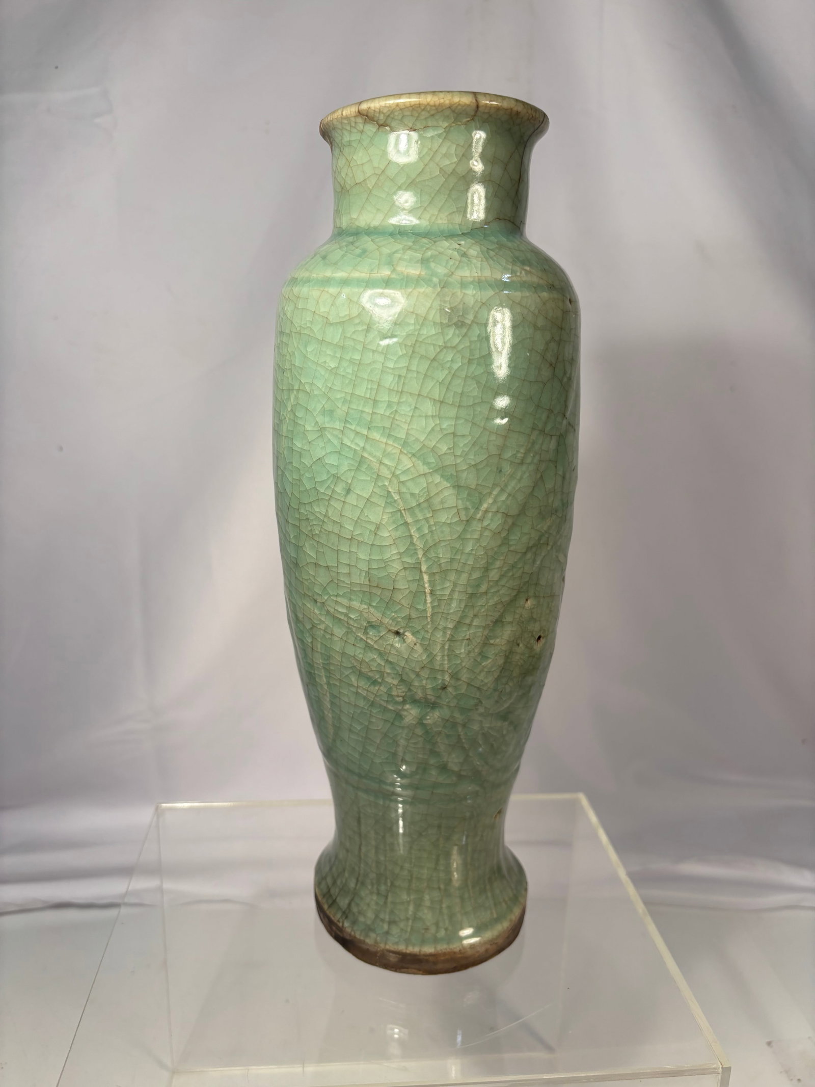 Chinese Longquan-style Celadon Vase,: Chinese Longquan celadon vase, Ming Dynasty (1368–1644). The baluster-form body is decorated with molded foliate motifs beneath a pale green celadon glaze. The surface displays an overall crackled g