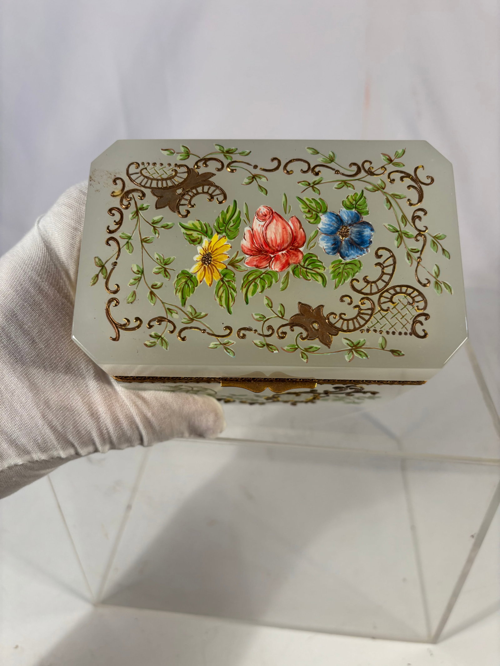 Murano Hand Painted Opaline Glass Jewelry Box, Signed Gino Cenedese: A fine Murano opaline glass casket, hand-painted with polychrome floral decoration and gilt scrolling vines. The base inscribed “dipinto a mano … Gino Cenedese Murano.” Mounted with gilt met