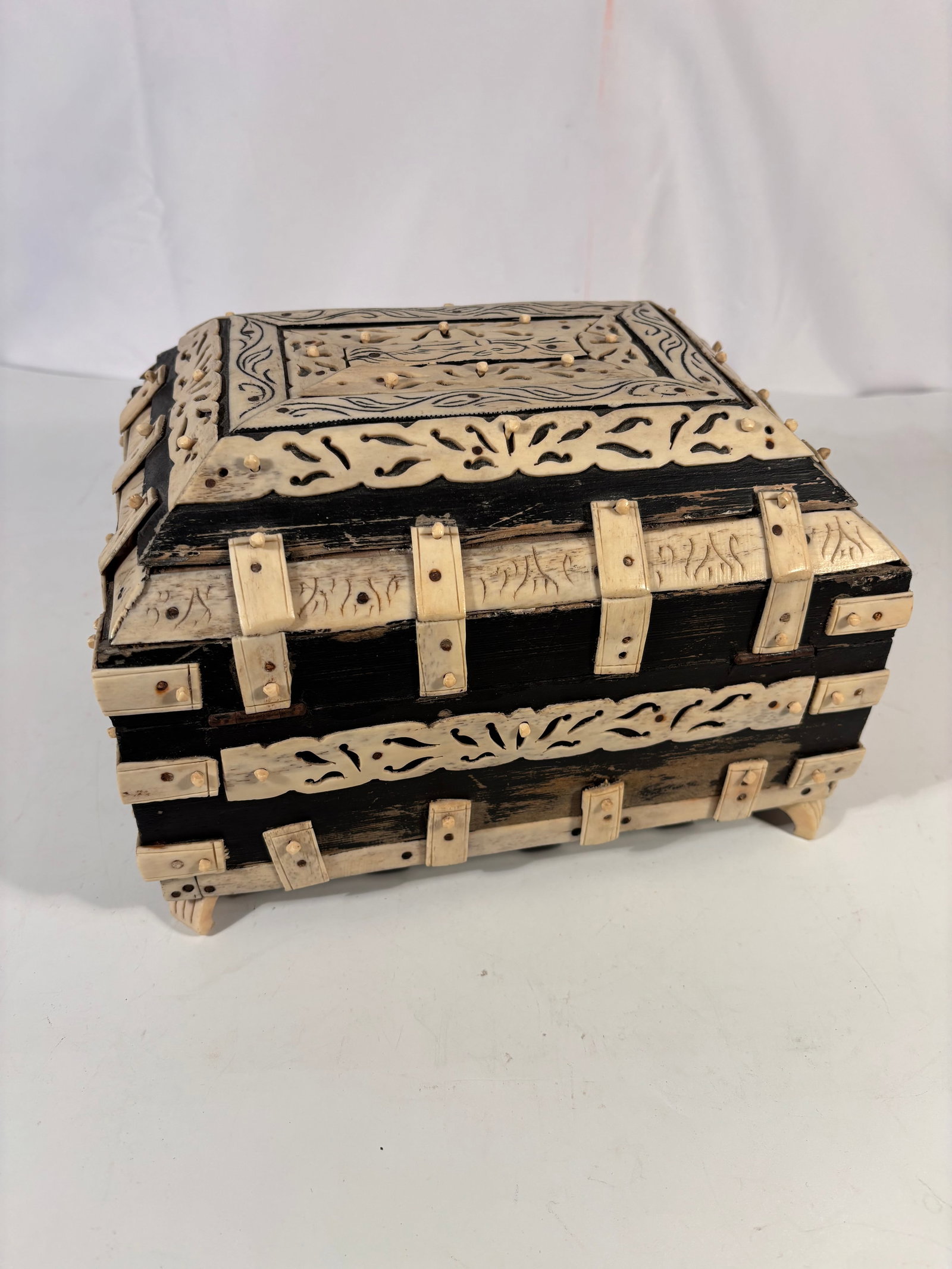 An Anglo-Indian Vizagapatam Mughal Style Bone Overlay Footed Casket Box, 19th C.: A fine 19th century Anglo-Indian Vizagapatam footed casket box, crafted in wood with elaborate carved bone overlay in the Mughal taste. The domed lid and sides are richly adorned with pierced scrollin