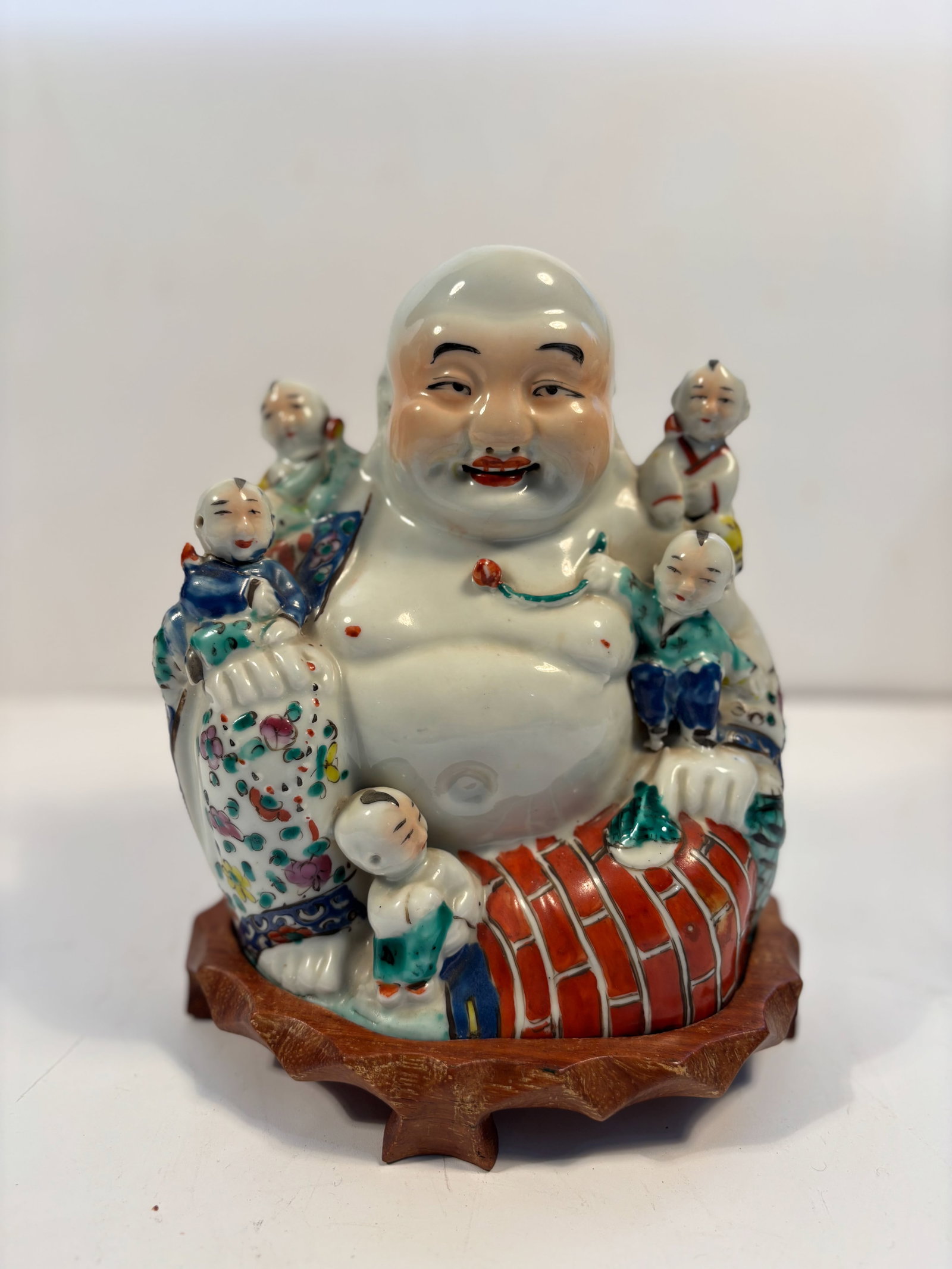 A CHINESE PORCELAIN FAMILLE ROSE OF HAPPY BUDDHA W/ CHILDREN: Qing Dynasty (1644-1912); This is a beautiful large antique Chinese figure of a Buddha with chidren.Dimensions?8" high without base, base inclued height: 9 inches. Width: 7 inches.