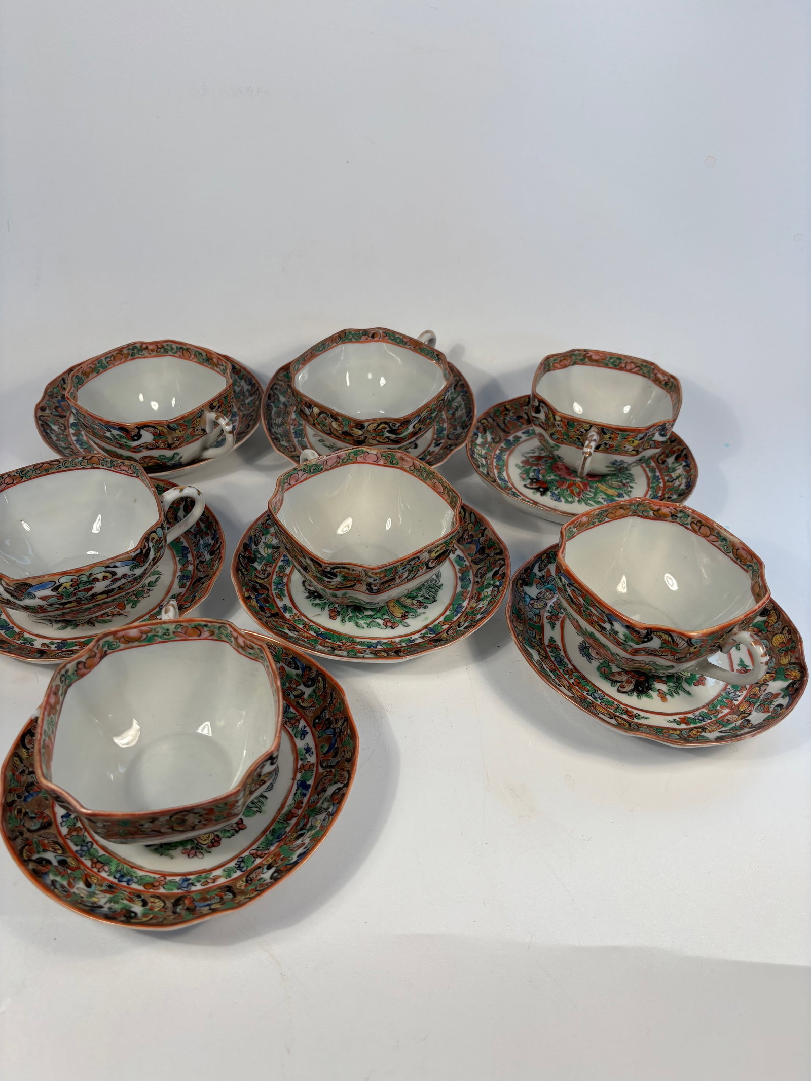 A set of 7 teacups and 7 saucers dessert plates: Qing Dynasty (1644-1912); Rose Medallion style, identifiable by the vibrant medallions with flowers, birds, and butterflies, and a gilt rim.Dimensions?QQ