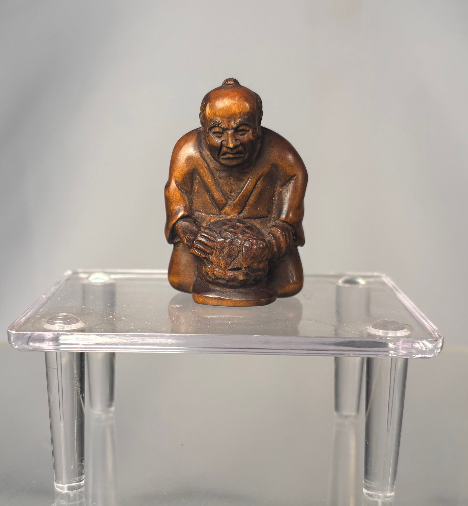 A Japanese Boxwood Netsuke of a Seated Oni on a Barrel, Signed (Gyokumatsu)